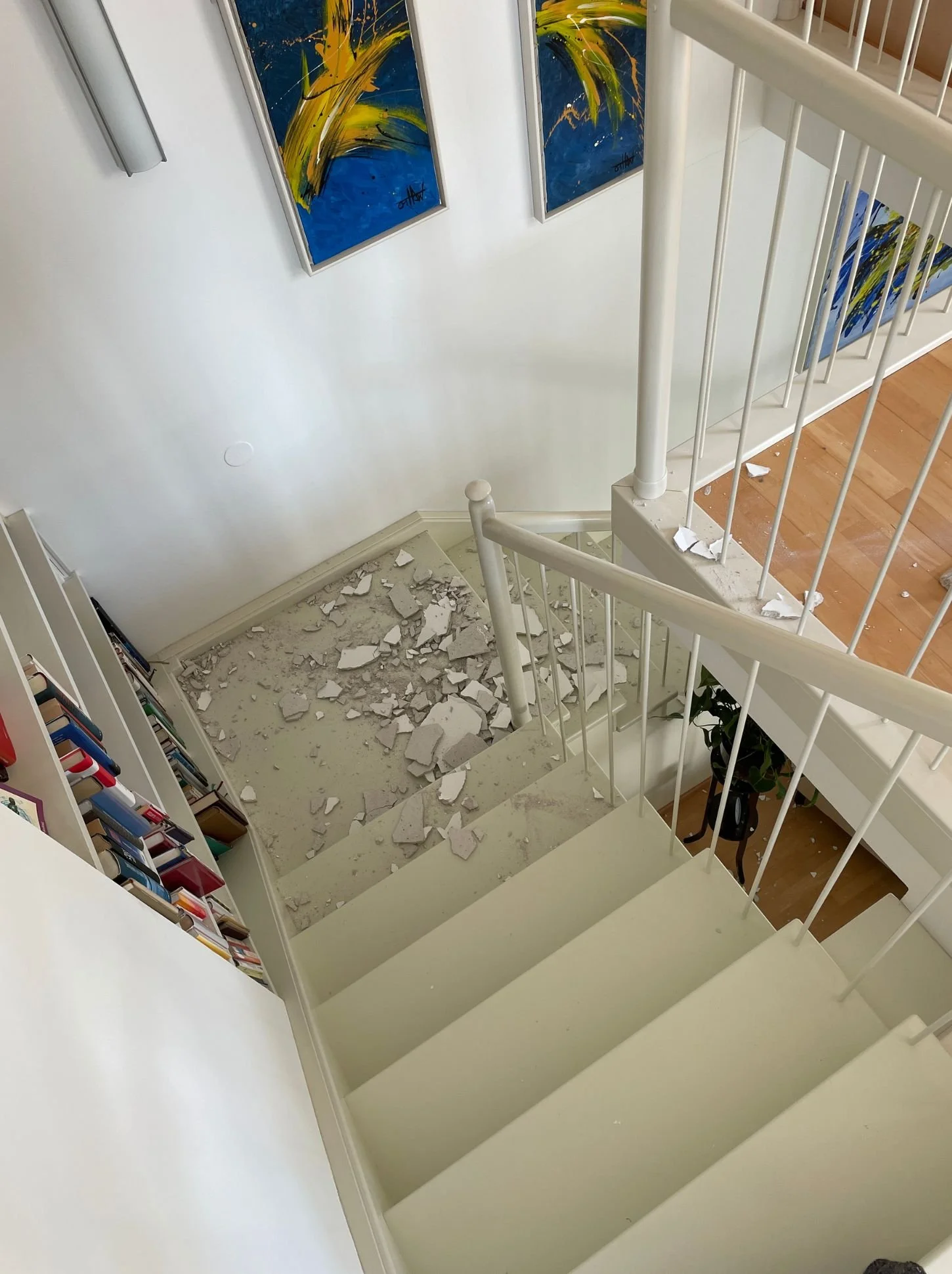 Treppenhaus mit Schutt und beschädigter Decke nach einem Wasserschaden vor der Instandsetzung und Sanierung