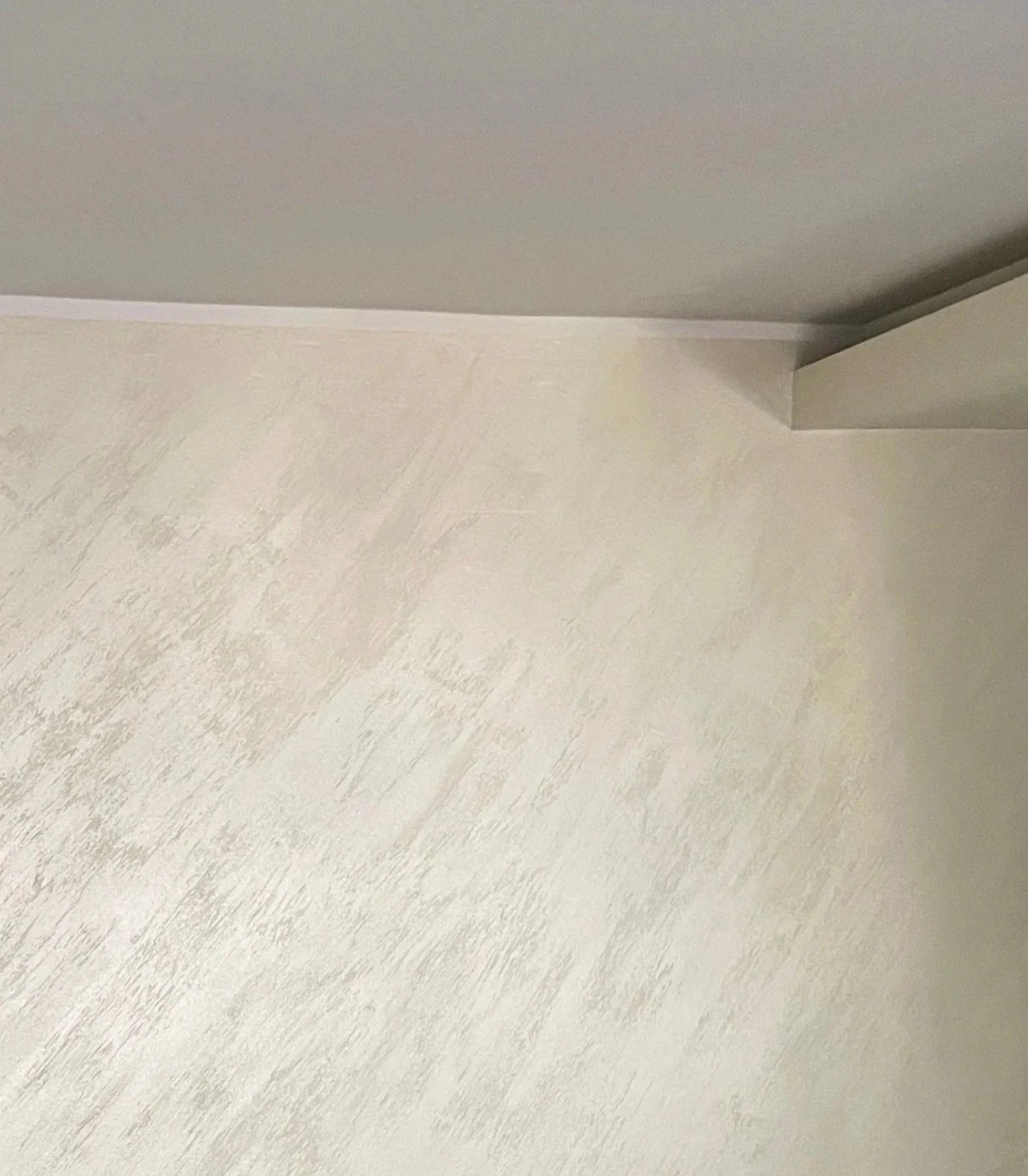 Weiter Blick auf einer weißen Holzfußboden in einem Raum mit einer weißen Wand und einer Decke, die in dunklerer Farbe gestrichen ist.