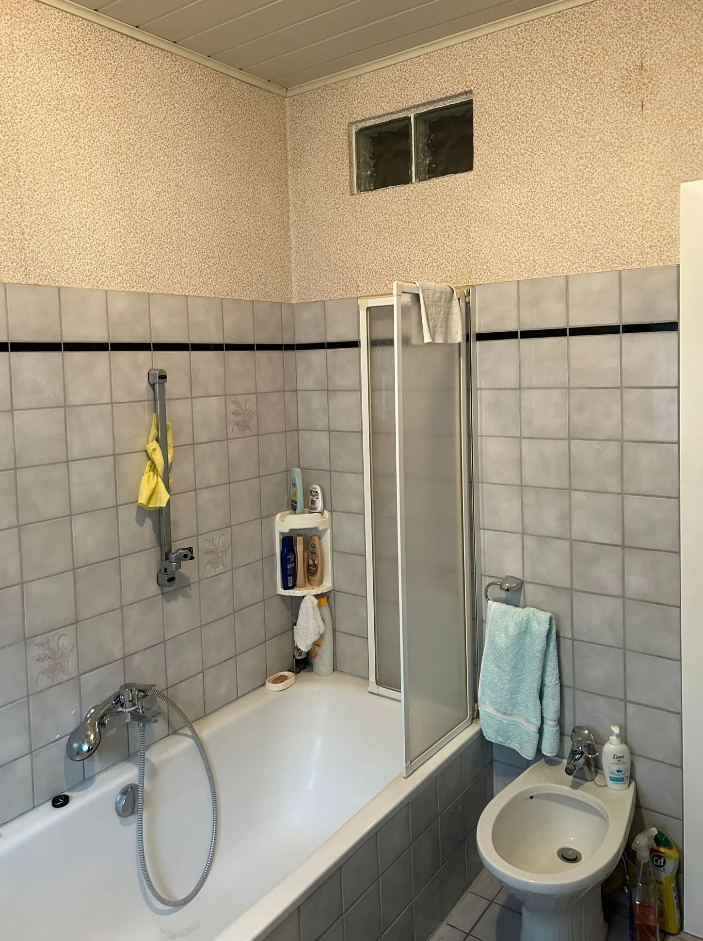 Vorher-Bild eines Badezimmers mit alten Fliesen, Badewanne und klassischer Wandgestaltung vor der Modernisierung mit fugenlosen Oberflächen