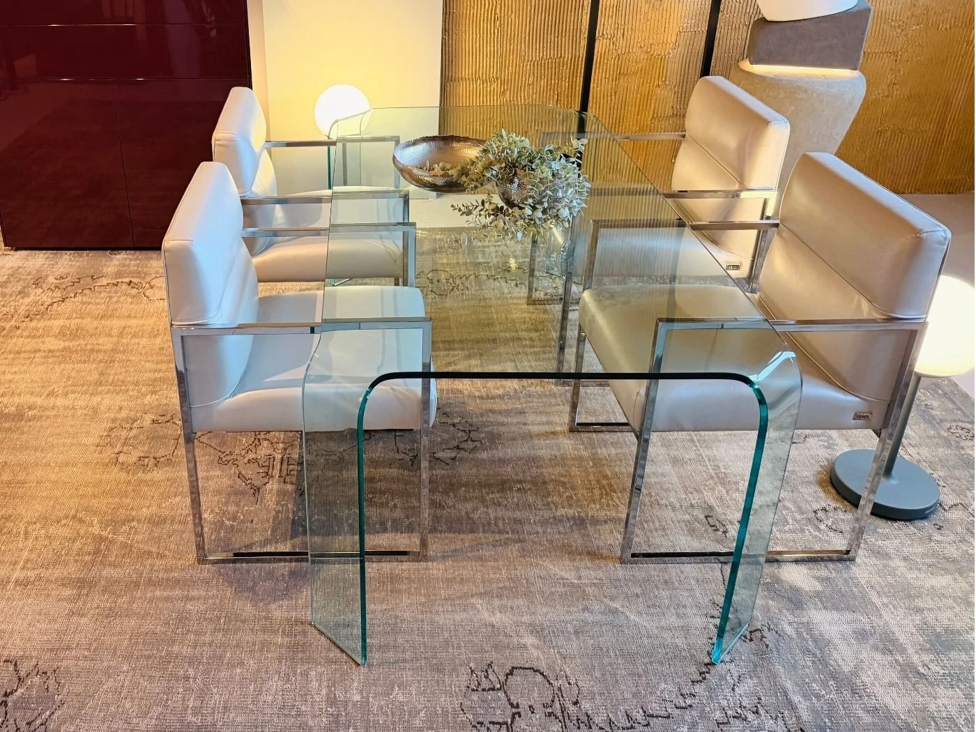 Esszimmer mit gläsernem Tisch und sechs hellen Polsterstühlen