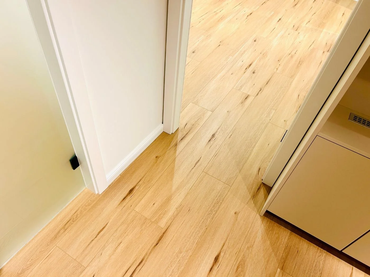 Detailansicht eines neu verlegten Vinylbodens im Flur mit heller Holzoptik, präzisen Übergängen und hochwertiger Ausführung