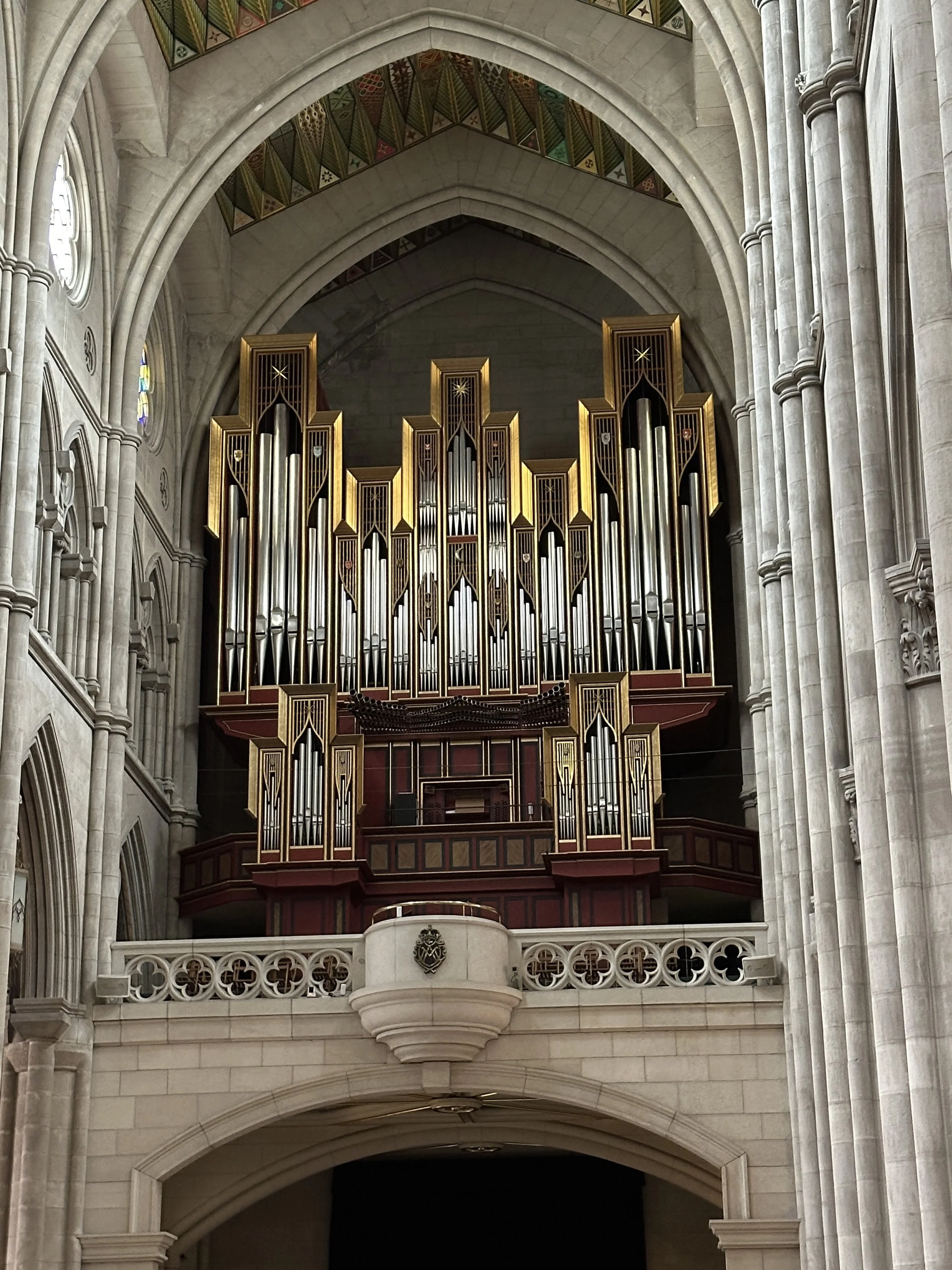 Ein großes Orgelinstrument in einer gotischen Kirche mit hohen, steinernen Säulen und einem kunstvollen Gewölbedach.