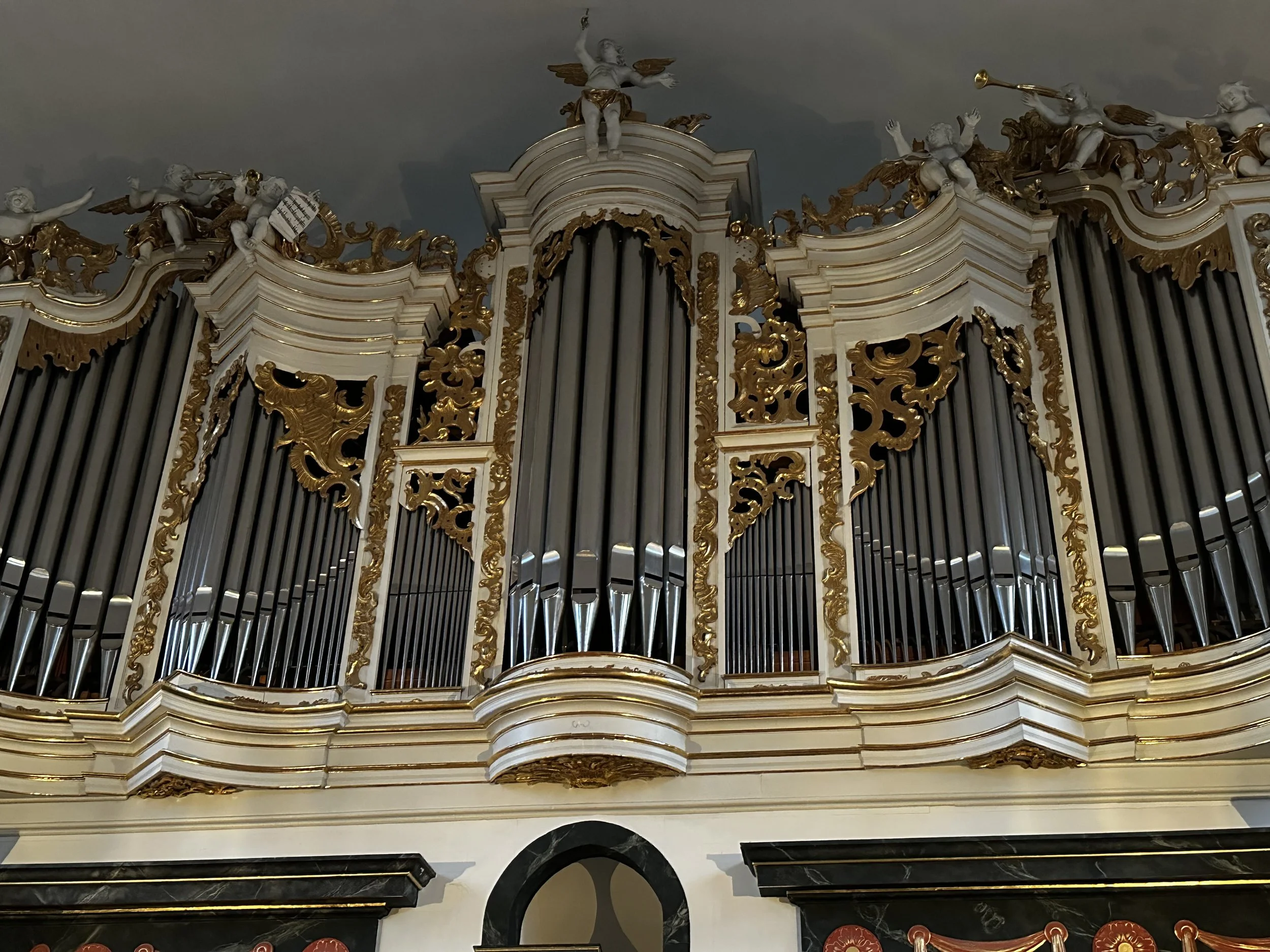 Barock-Orgel mit goldenen Verzierungen und Skulpturen in einem Kirchenraum.