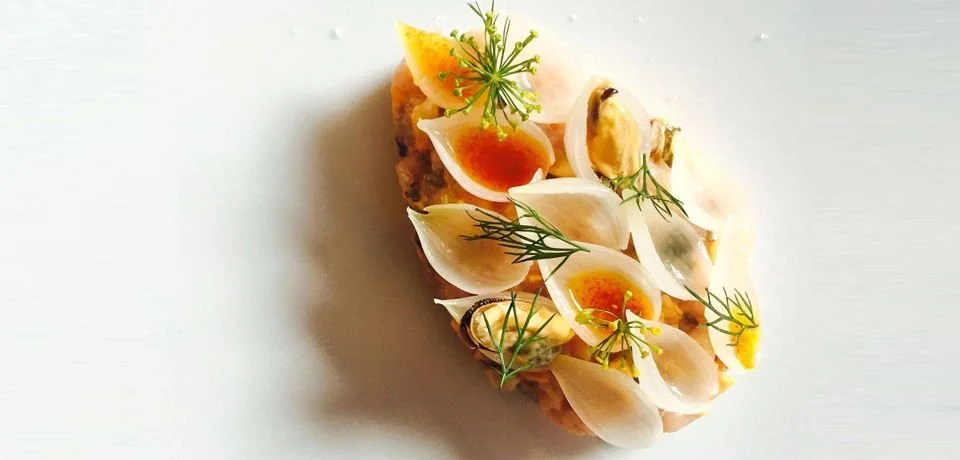 Une tranche de pain garnie de morceaux d'œuf dur, herbes, et sauce.