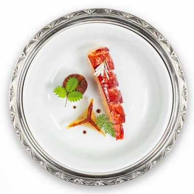 Boeuf tartare aiguisé avec une garniture de feuilles de coriandre et de sauce sur une assiette élégante.