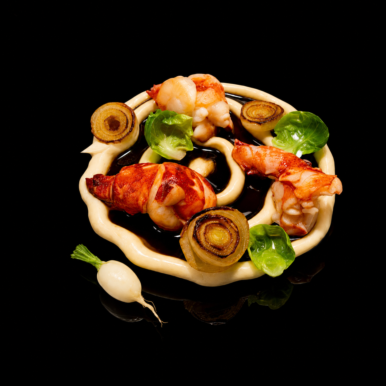 Gros plan d'un plat de fruits de mer avec des crevettes, des oignons grillés, de la laitue, une sauce brune, de la crème, et une petite radis blanche, présenté sur un fond noir.