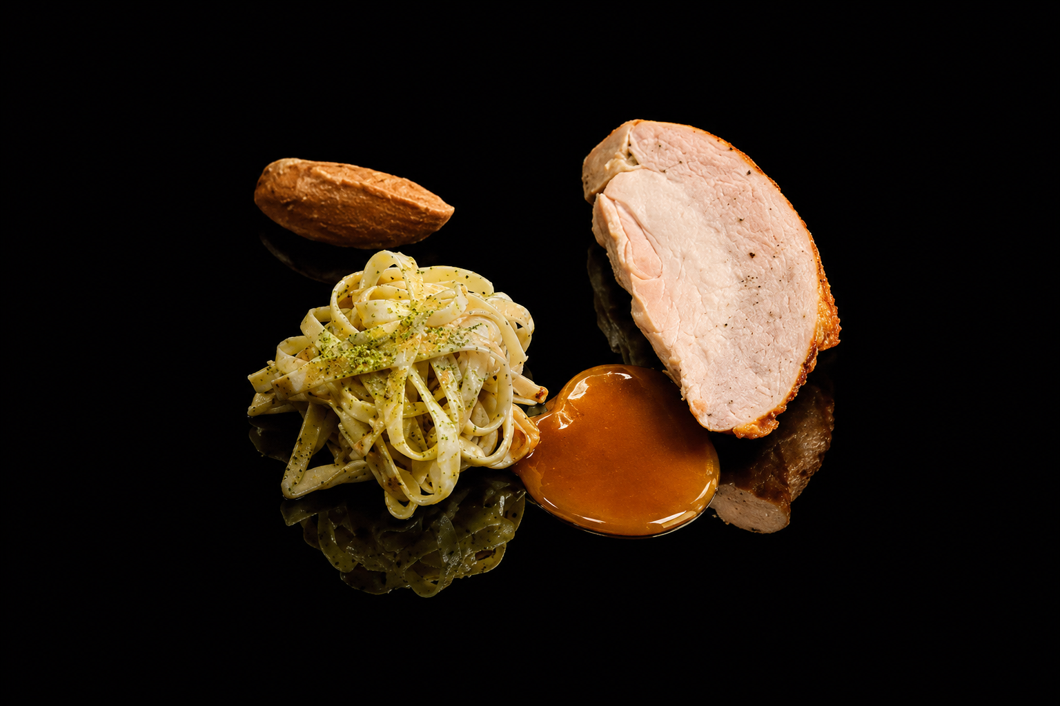 Assiette avec une portion de pâtes, un morceau de viande, de la sauce et un amande