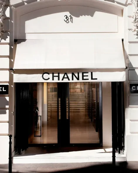 Entrée d'une boutique Chanel avec enseigne et porte en verre.