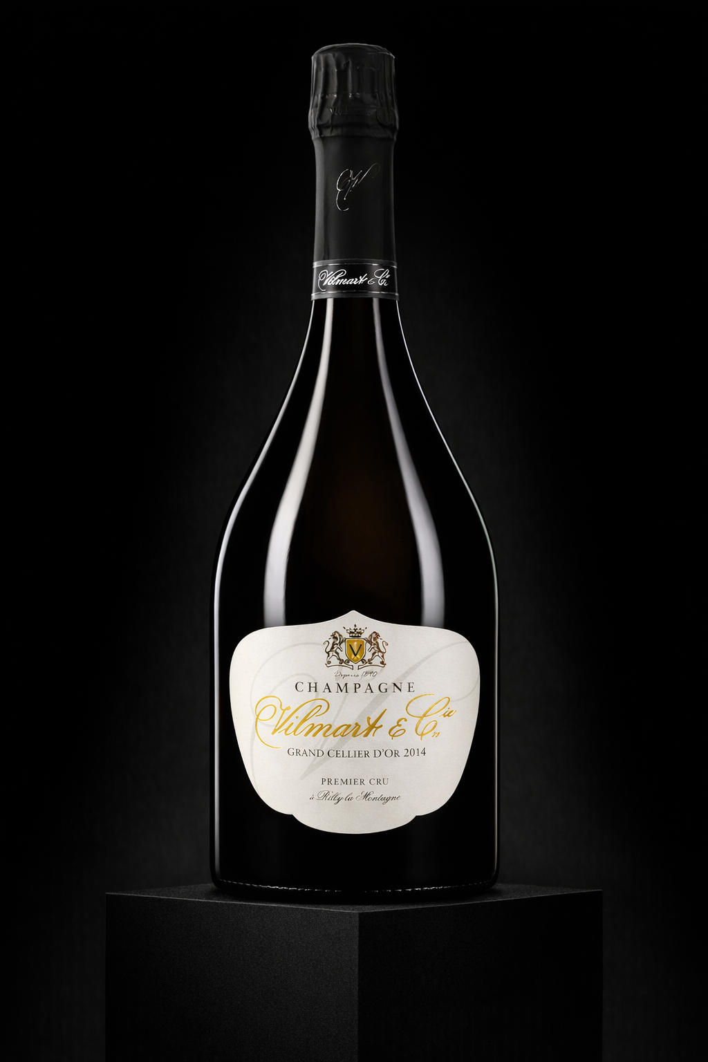 Une bouteille de champagne noire sur un socle noir avec une étiquette blanche et grise, portant le nom Vilmart & Co, mentionnant Grand Cellier d'Or 2014, Premier Cru, et la région de Champagne.
