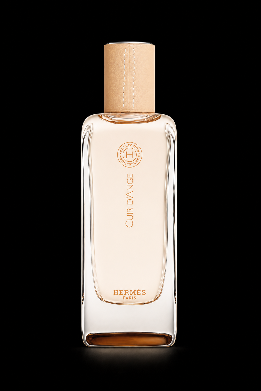 Flacon de parfum Hermès 'Cuir D'Ange' avec un capuchon en cuir beige sur fond noir.