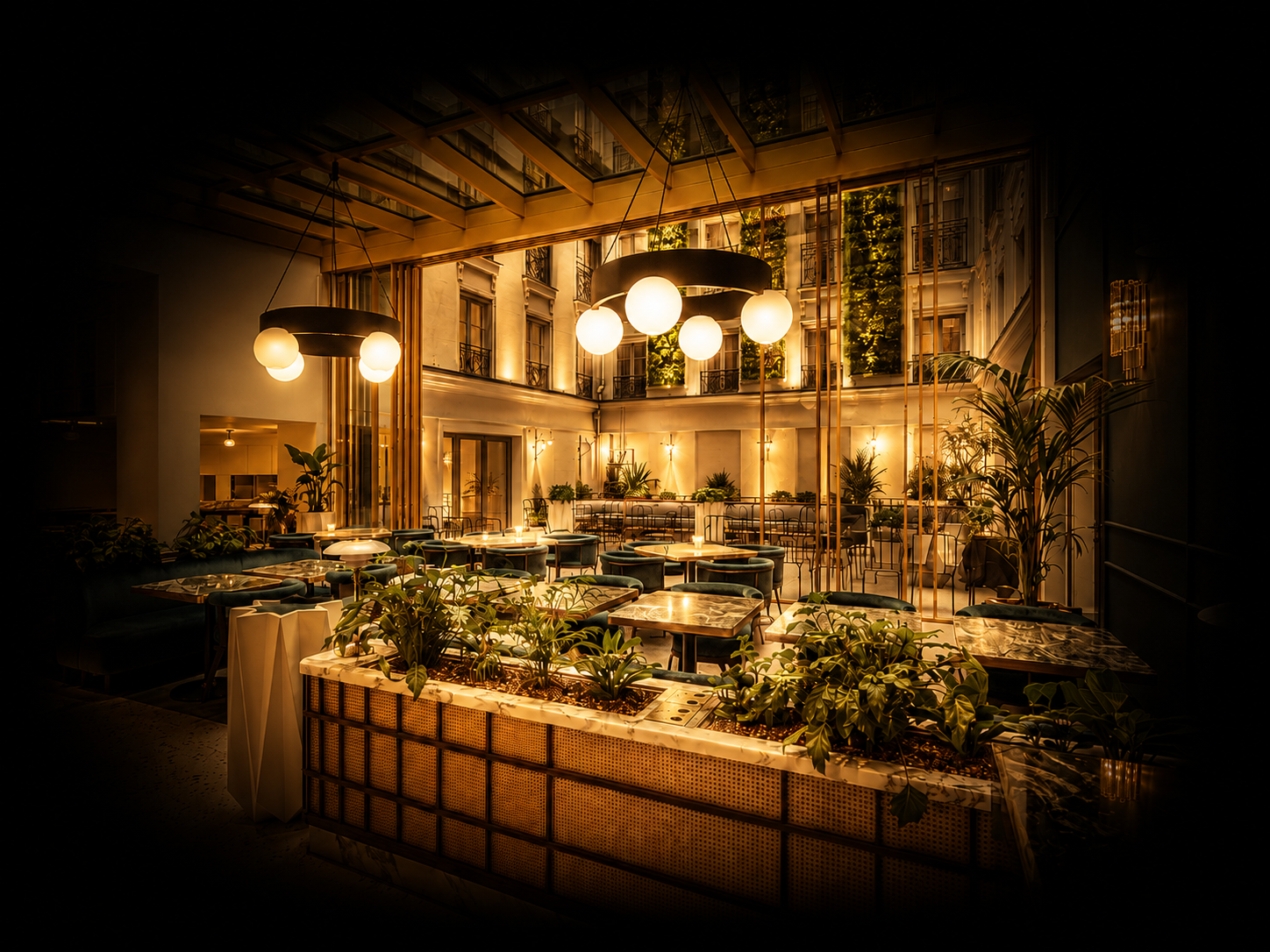 Salle de restaurant élégante avec éclairage chaud, plantes vertes, tables en marbre et sièges en velours vert foncé, grandes fenêtres laissant entrer la lumière naturelle.