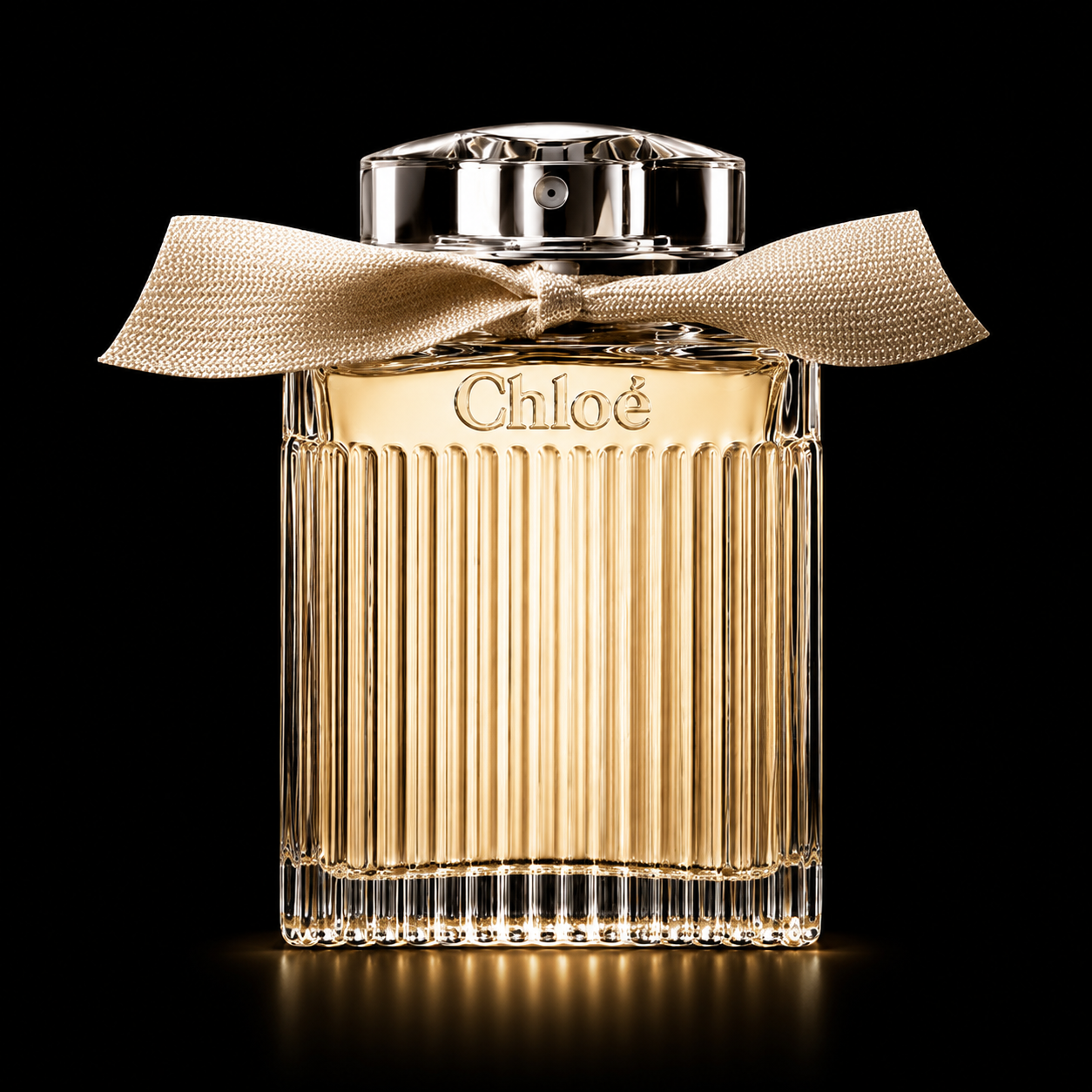 Flacon de parfum Chloé avec un ruban beige et un fond noir.