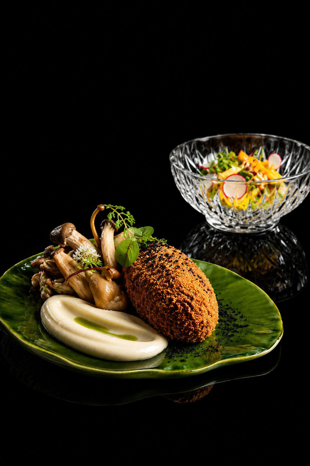 Assiette avec un cordon bleu, des champignons sautés, une purée de céleri-rave et des herbes, accompagnée d'une salade en bord de verre en cristal.