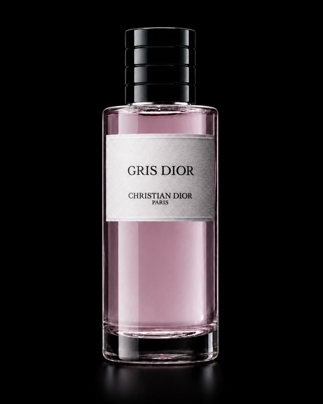 Flacon de parfum appelé Gris Dior de Christian Dior, avec un liquide rose pâle dans un flacon en verre transparent, sur un fond noir.