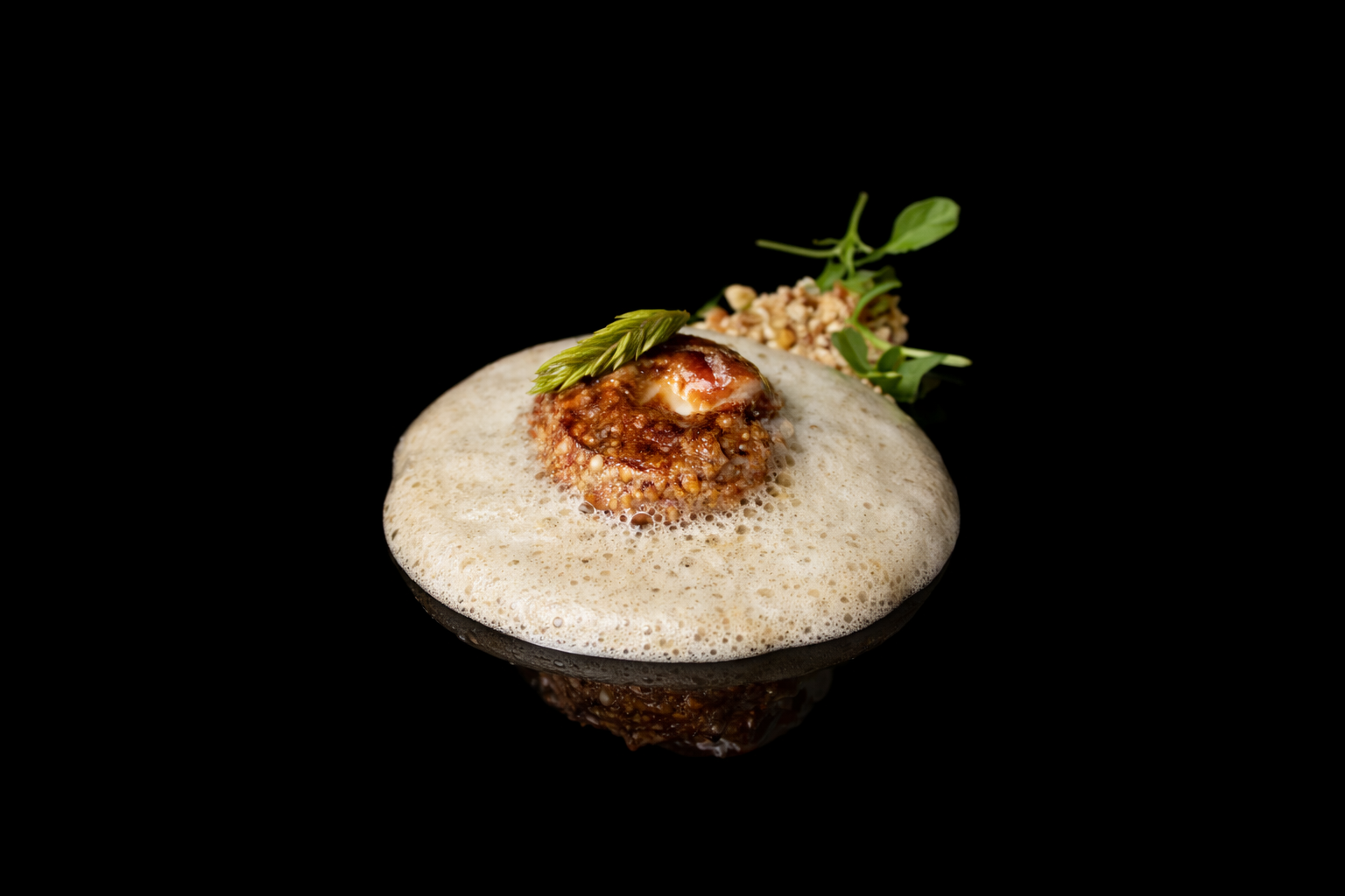 Plat gastronomique avec un œuf mollet, sauce, petite herbe et graines, sur une plaque noire