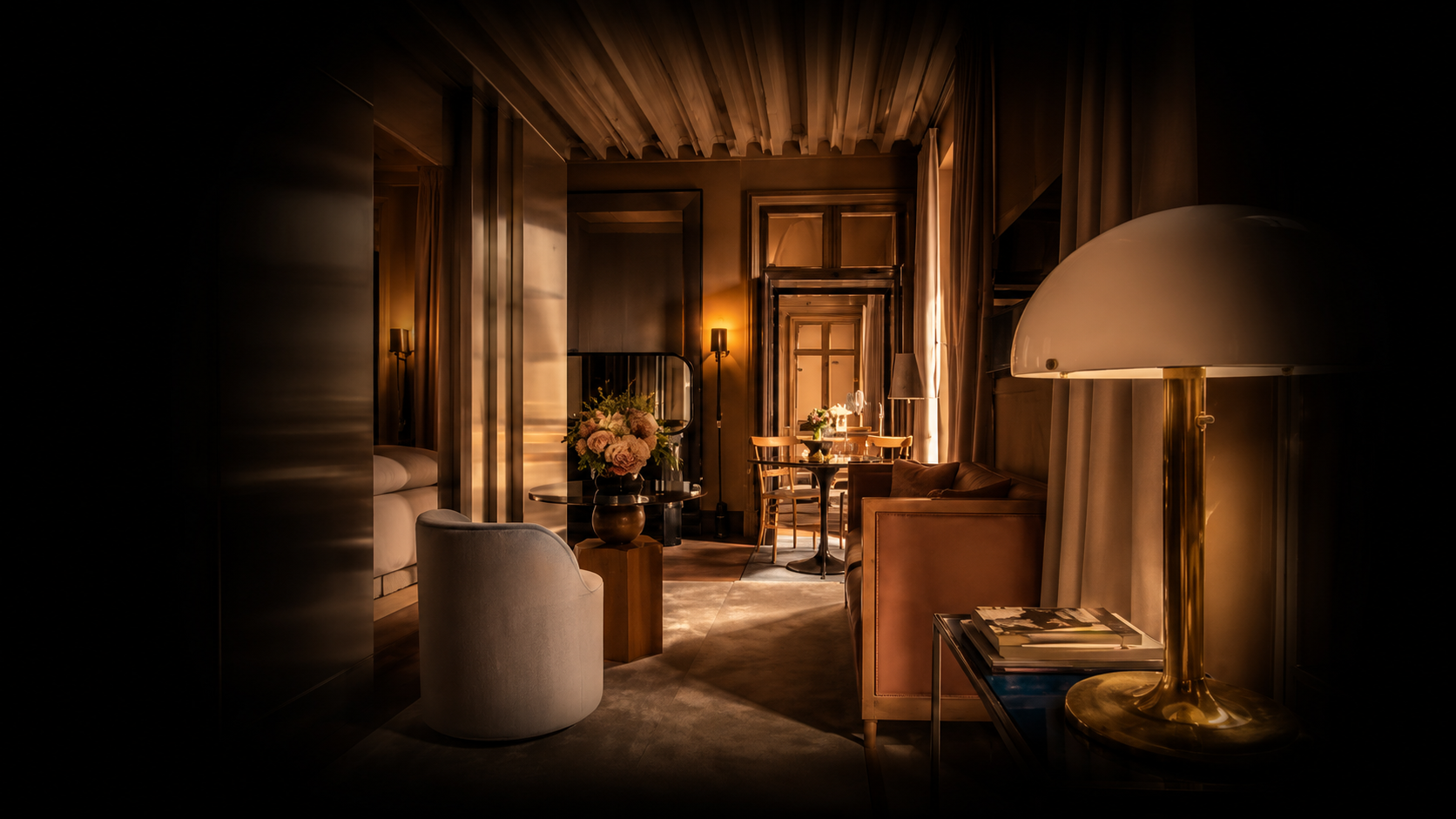 Intérieur chaleureux d’un salon avec des meubles en bois, une table basse décorée de fleurs, un canapé en cuir, une lampe de bureau en or et un éclairage tamisé.