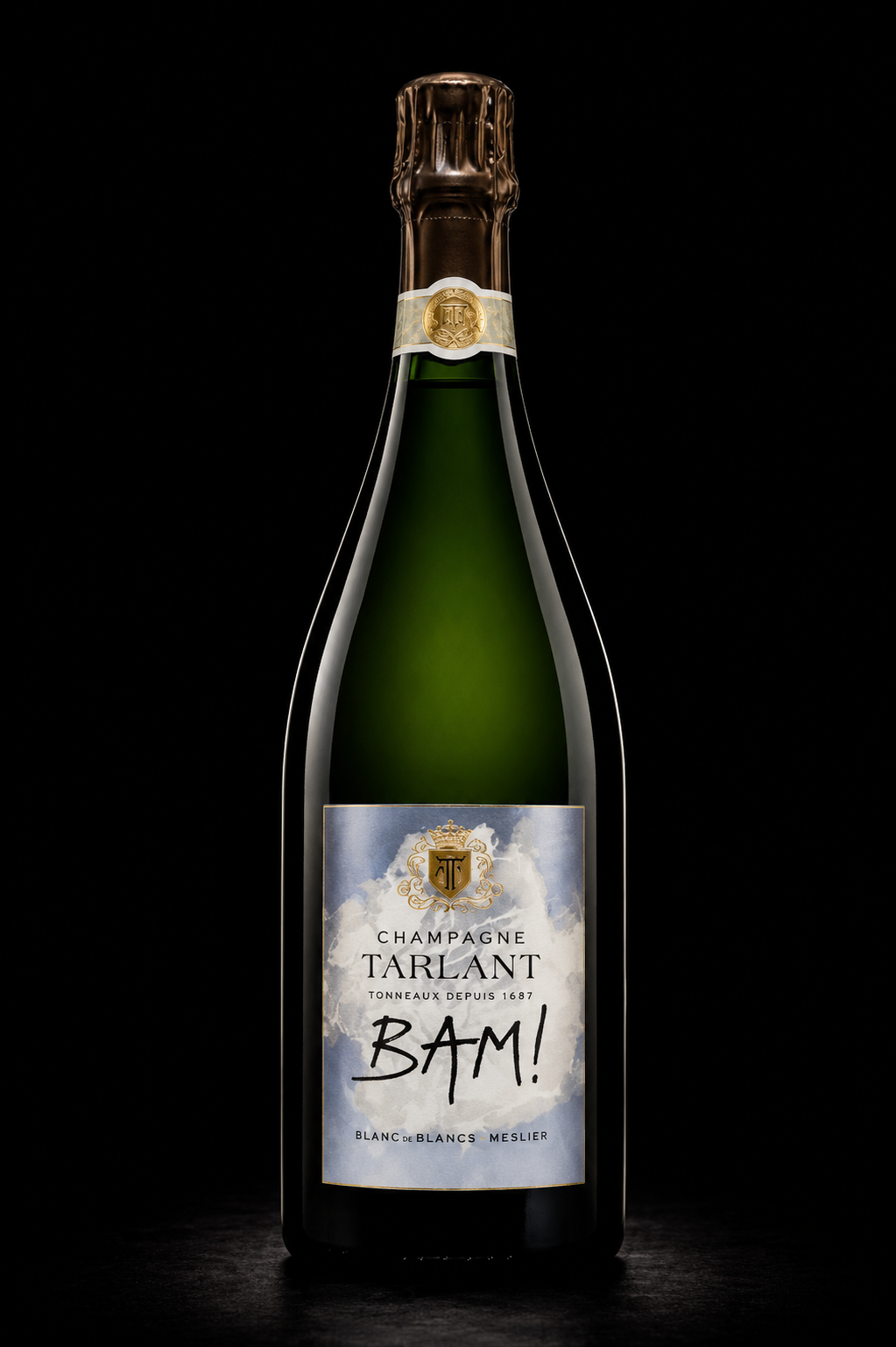 Une bouteille de champagne Tarlant Blanc de Blancs Meslier avec une étiquette comportant un logo doré en haut, un fond nuageux, et le mot "BAM!" écrit de manière expressive.