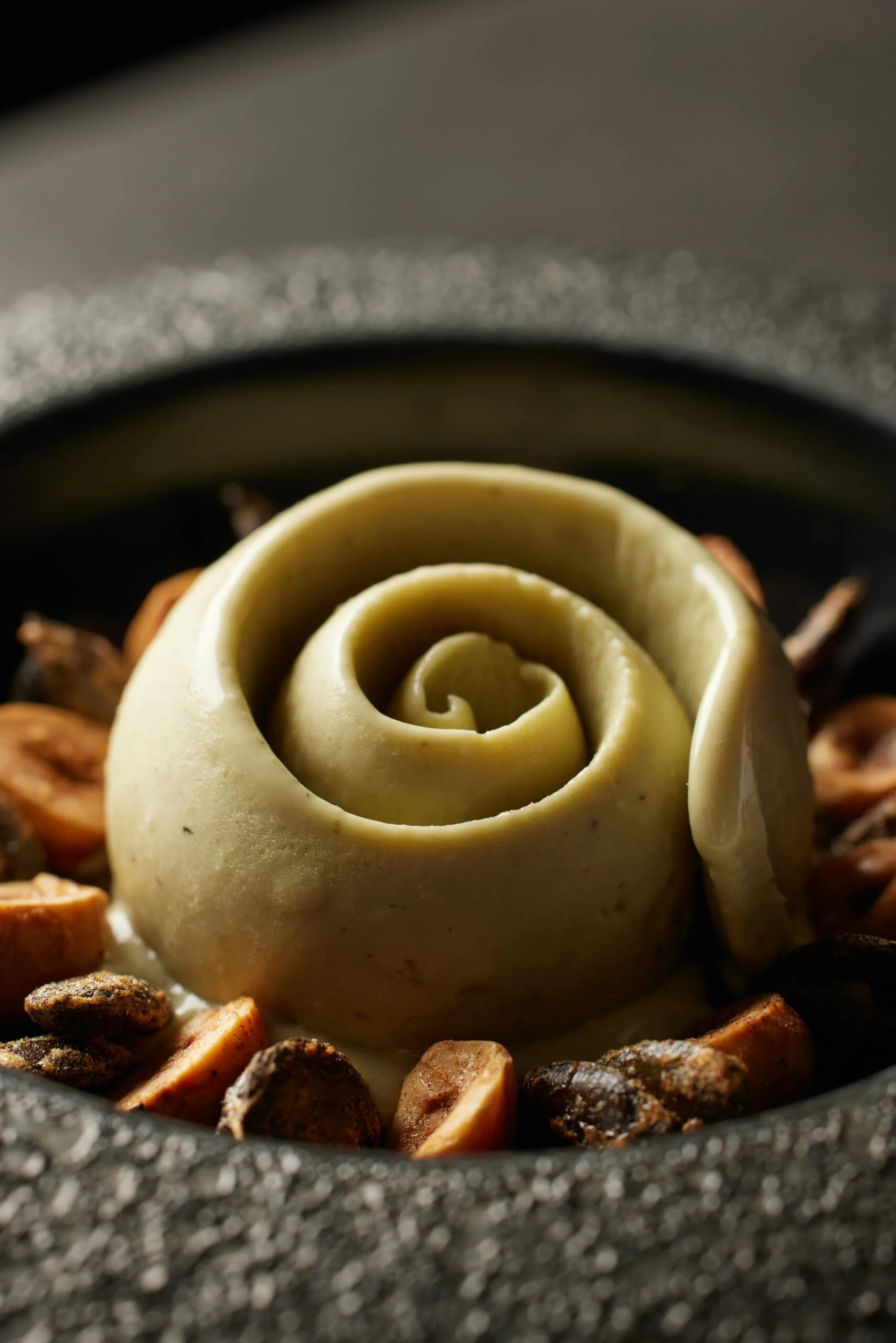 Une rose en pâte à cake design au centre d'un plat, entourée de morceaux de caramel croquant.