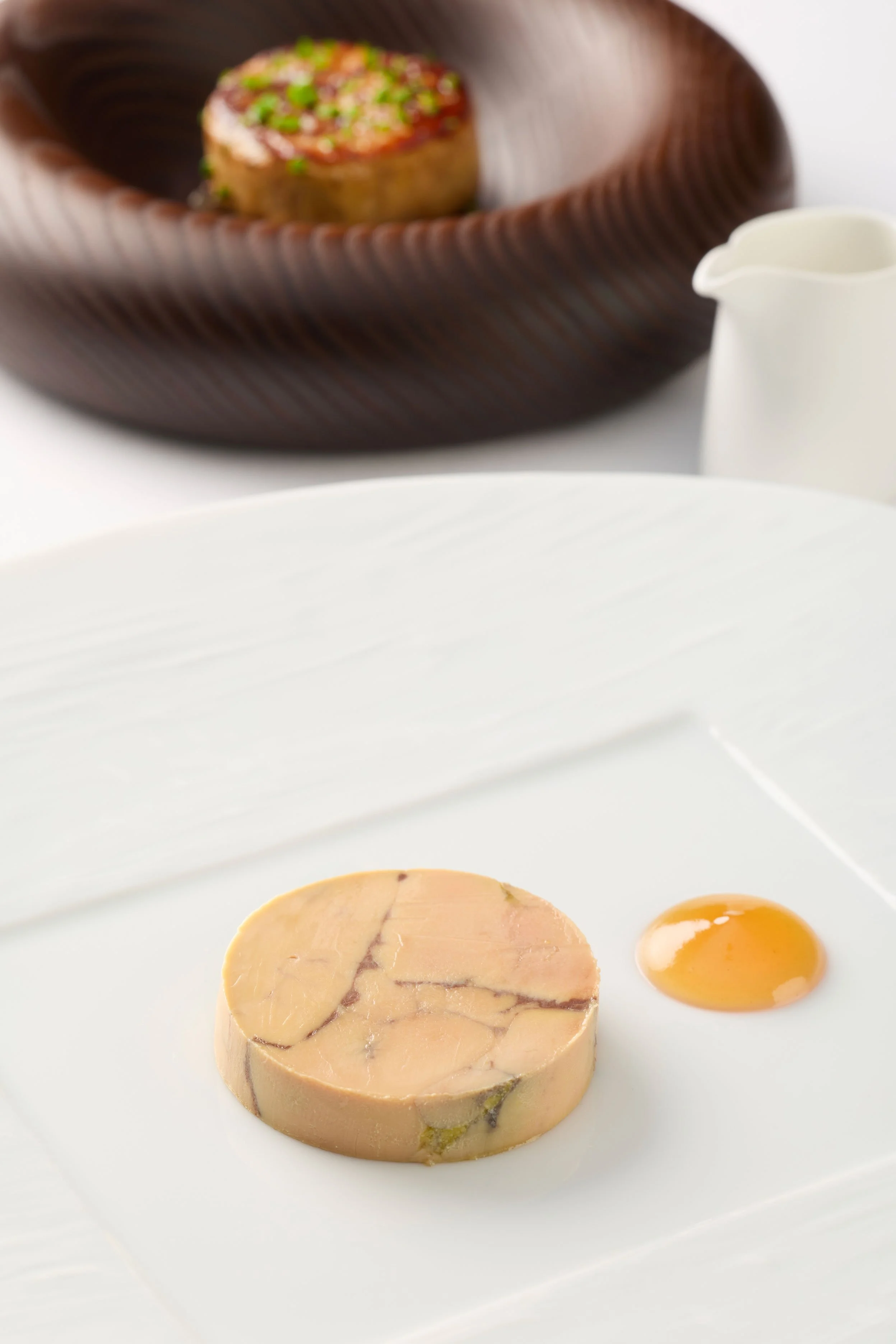 Terrine de foie gras avec œuf de caille sur une assiette blanche