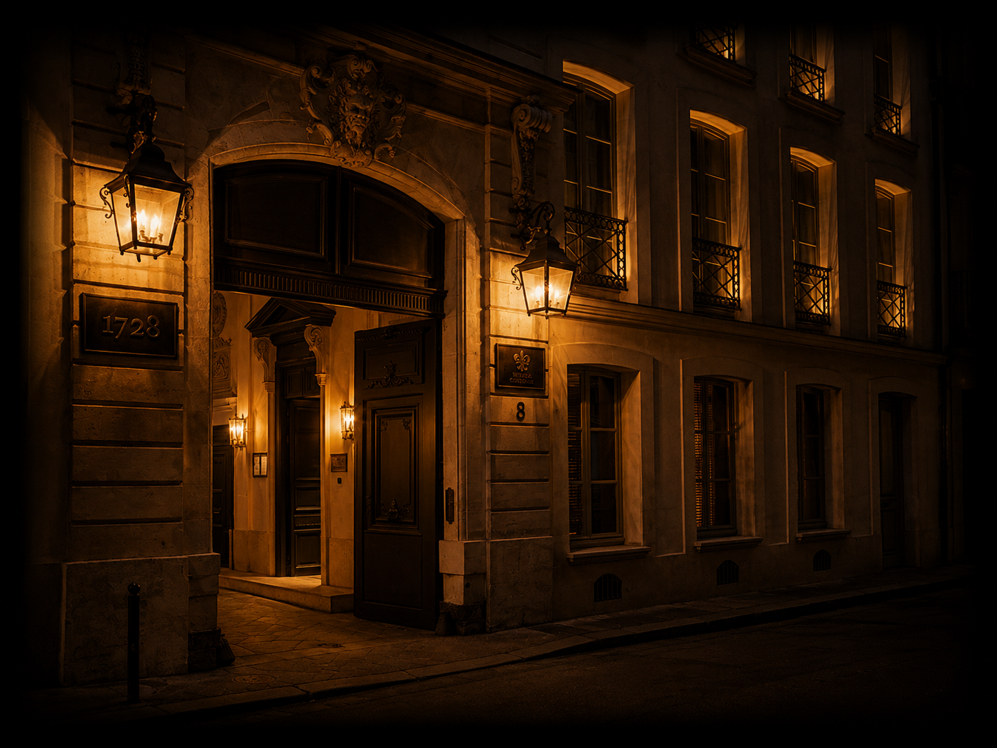 Une façade d'immeuble élégante illuminée par des lampes extérieures, avec fenêtres et portes en bois sculpté, en plein nuit.