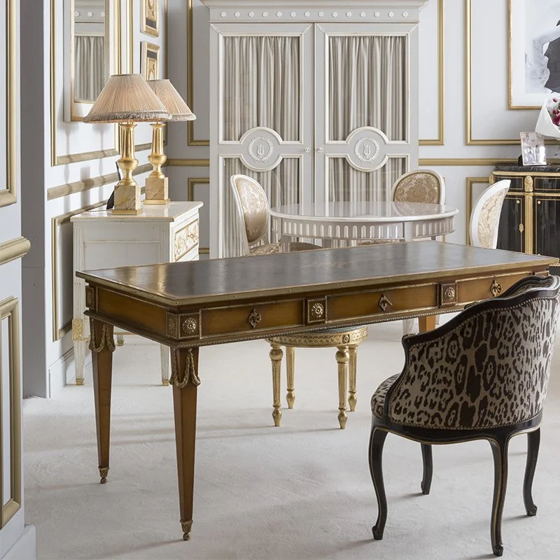 Une pièce élégante avec un bureau en bois, une lampe de table, des chaises rembourrées, un mur décoré avec des cadres dorés, et un meuble noir avec des ornements dorés.