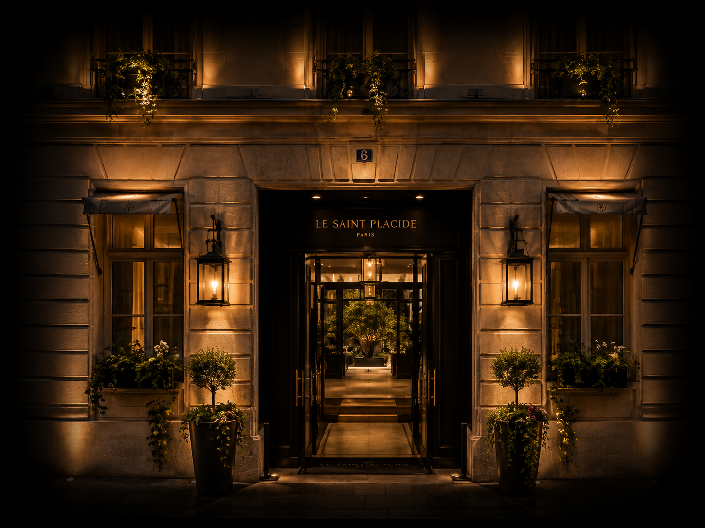 Facade d'un hôtel de luxe à Paris nommé "Le Saint Placide", avec une entrée éclairée, deux lampes extérieures, des plantes en pot et des fenêtres encadrées par des volets