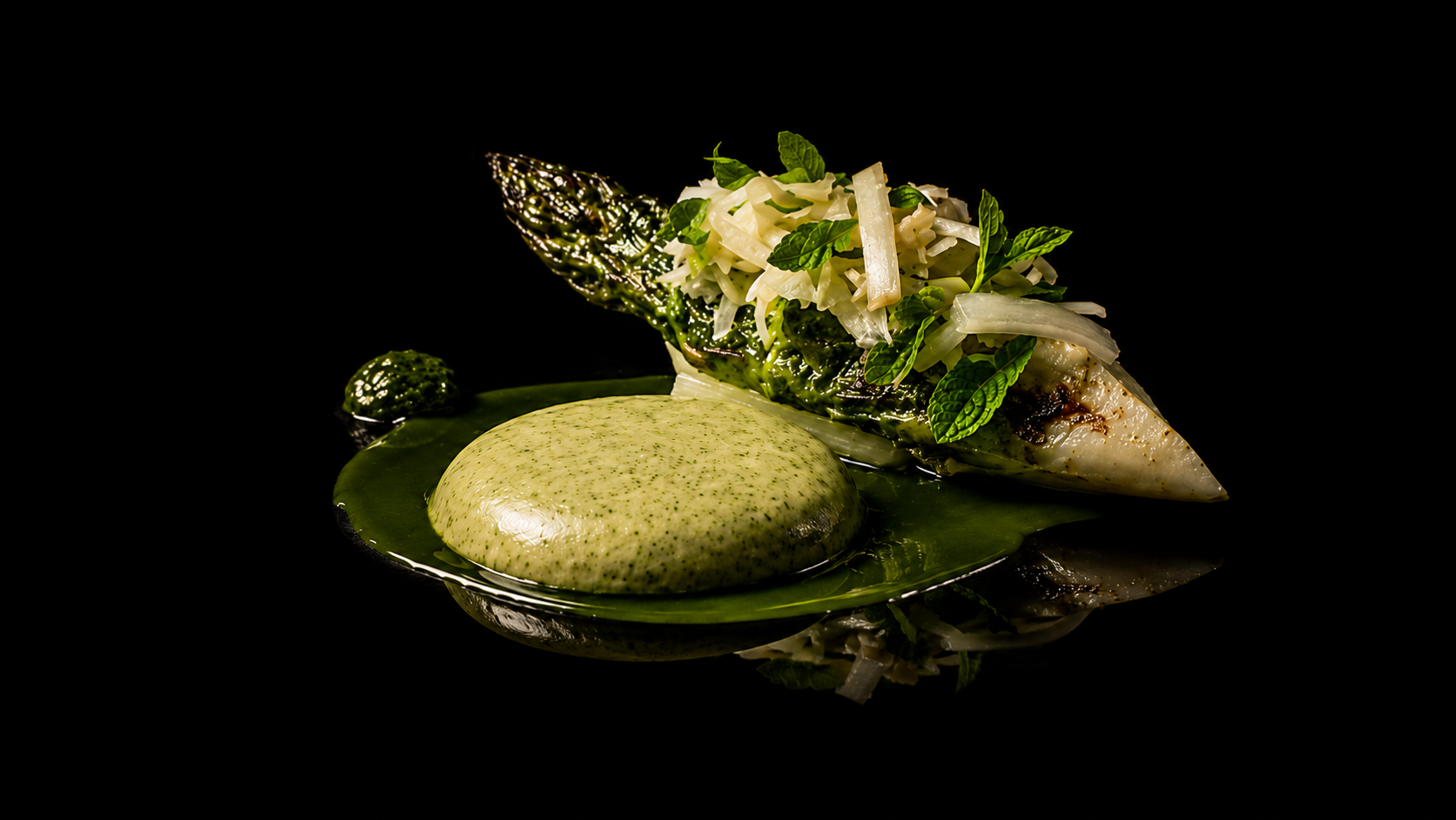 Assiette de poisson grillé garnie de légumes et sauce verte sur fond noir