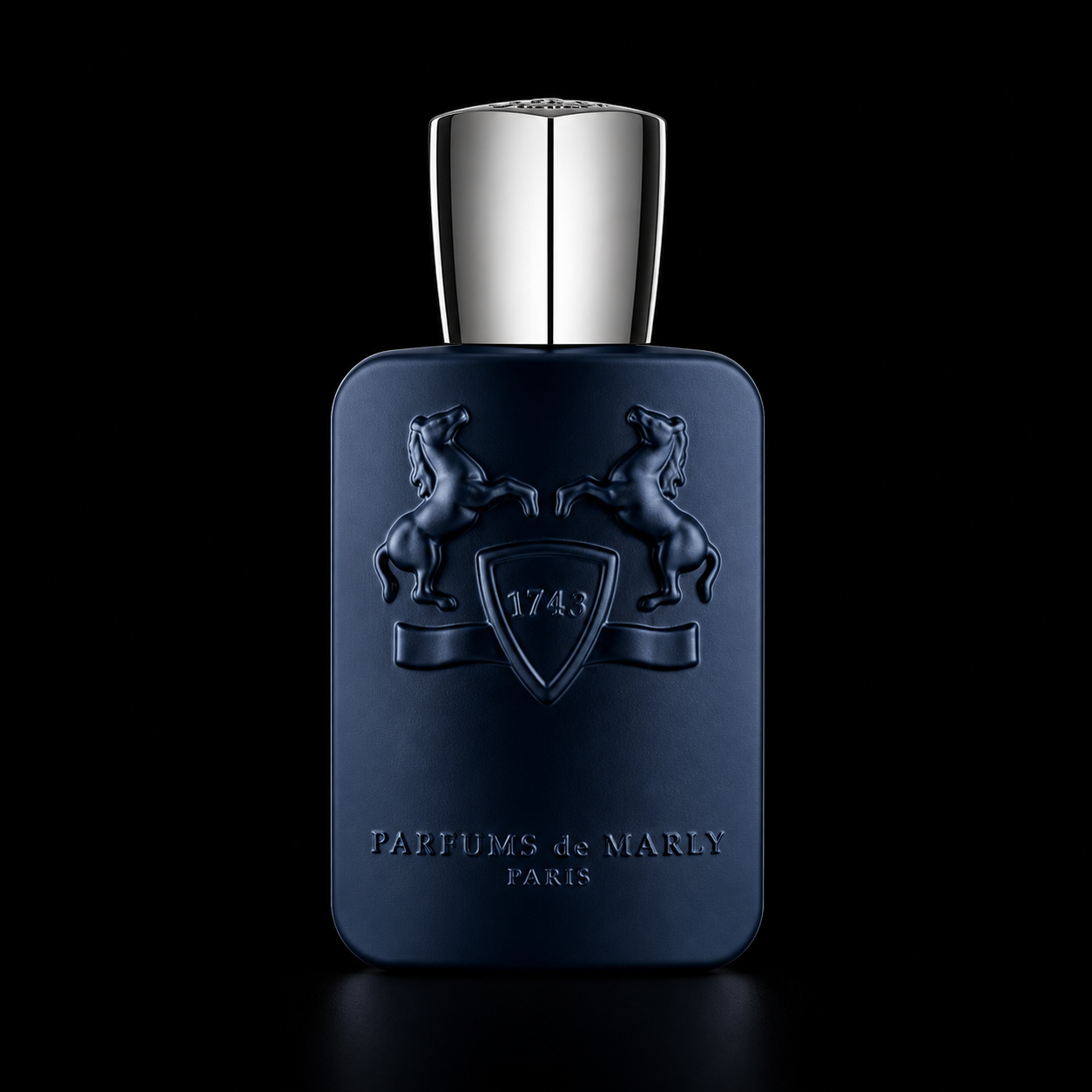 Une bouteille de parfum de couleur bleue foncée avec un capuchon argenté, ornée d'un blason avec deux chevaux et la date 1743, portant l'inscription "PARFUMS de MARLY PARIS".