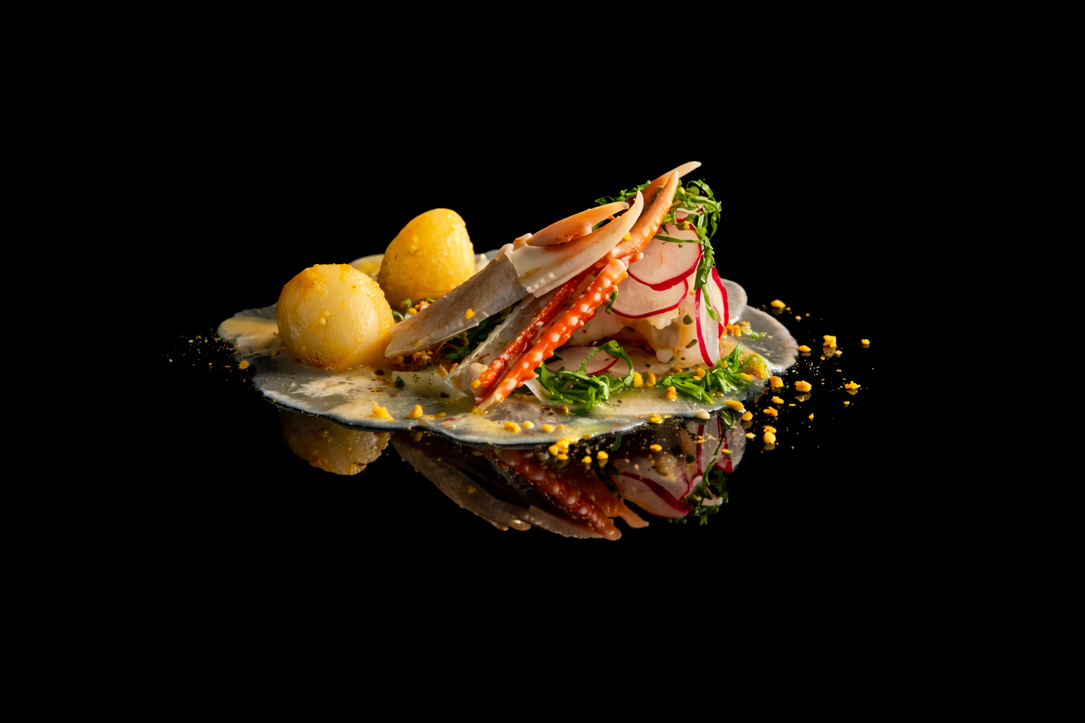 Assiette de fruits de mer avec radis, crevettes, et pommes de terre, sauce blanche, décoration verte, sur fond noir.