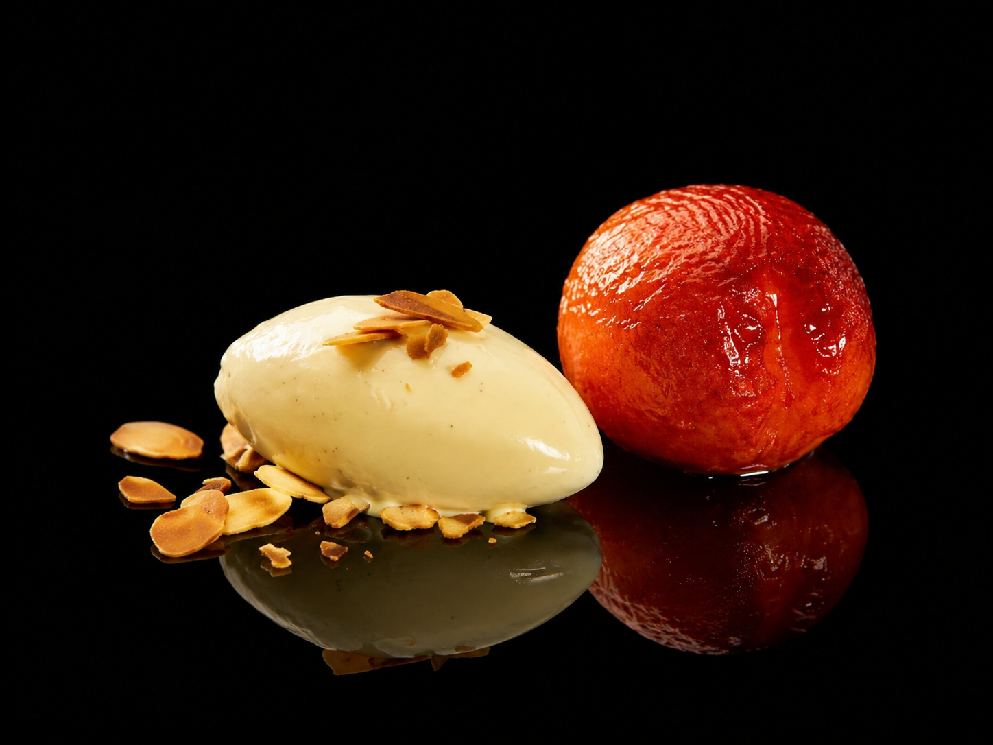 Boules de gommeux blanc et rouge, avec des amandes effilées, sur fond noir.