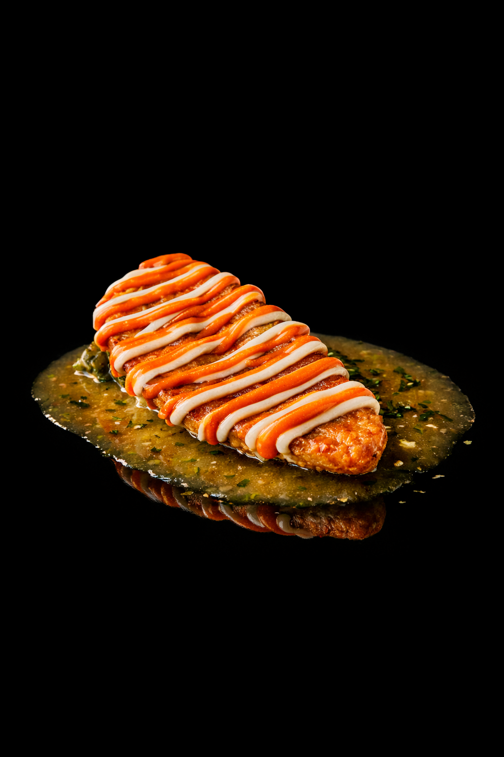 Plat de poisson en sauce, décoré de ketchup et mayonnaise, sur une surface noire