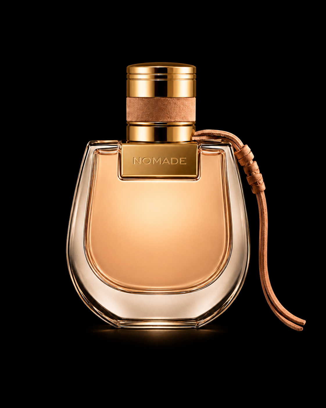 Flacon de parfum doré avec un ruban en cuir attaché, marqué NOMADE, sur fond noir.