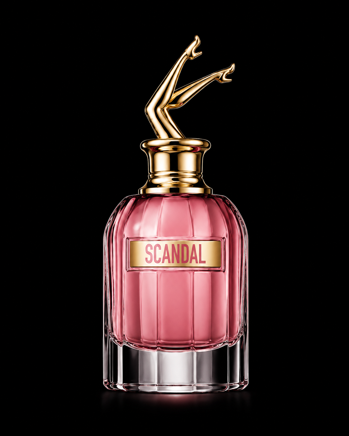 Flacon de parfum rose avec un label 'SCANDAL' et un bouchon or stylisé en forme de jambes.