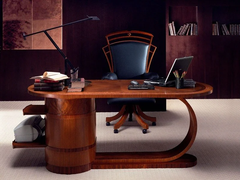 Un bureau en bois avec une chaise en cuir et un ordinateur portable, entouré de livres, d'une lampe de bureau, et d'accessoires de bureau dans un bureau élégant.