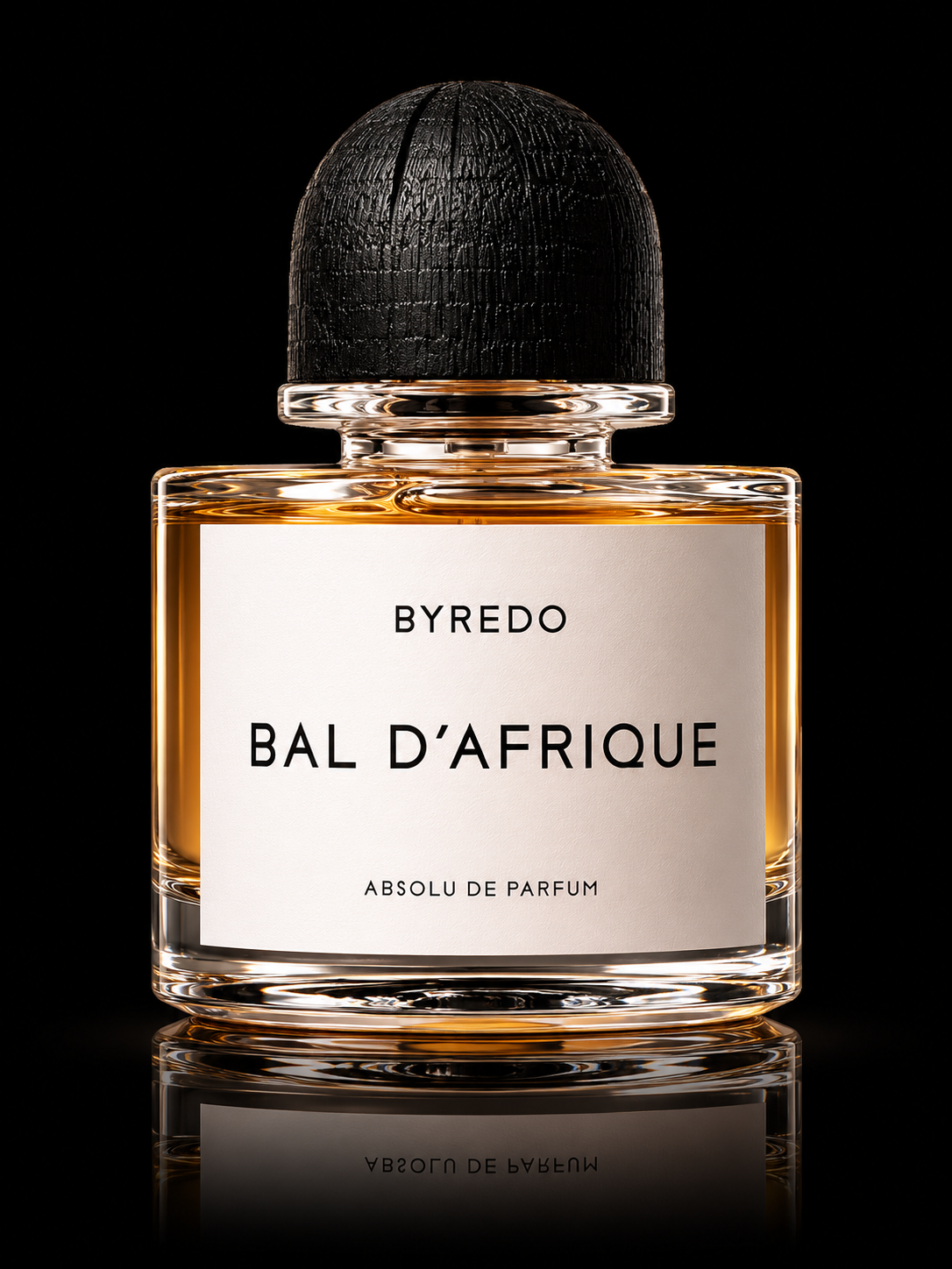 Lotion ou parfum dans un flacon transparent avec une étiquette blanche, intitulé 'Bal d'Afrique' de Byredo, avec un bouchon noir en bois.