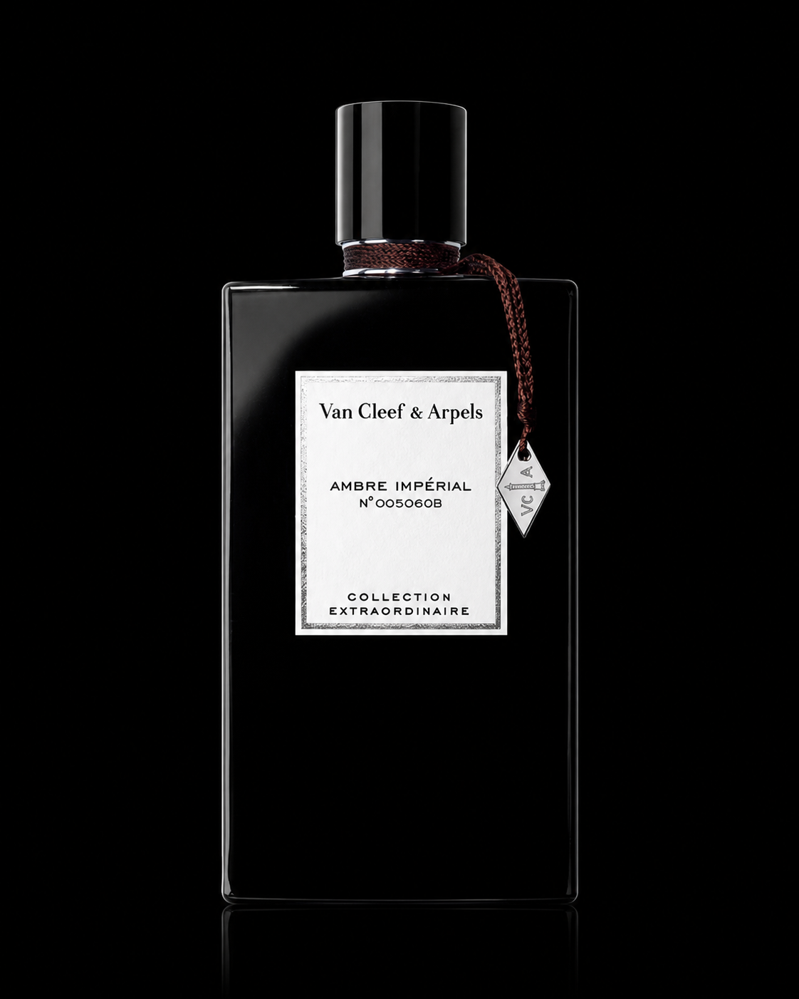 Une bouteille de parfum noire avec une étiquette blanche portant le nom Van Cleef & Arpels, collection extrordinaire, et un bouchon noir. La bouteille est ornée d’un ruban marron foncé attaché à une étiquette en forme de losange.