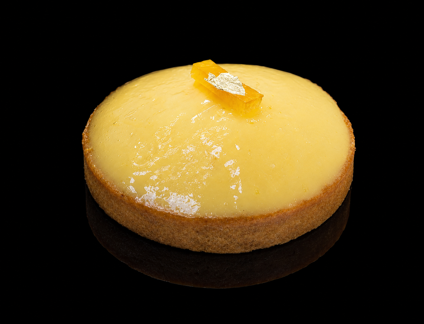 gâteau au citron avec une garniture de zeste de citron sur le dessus, fond noir