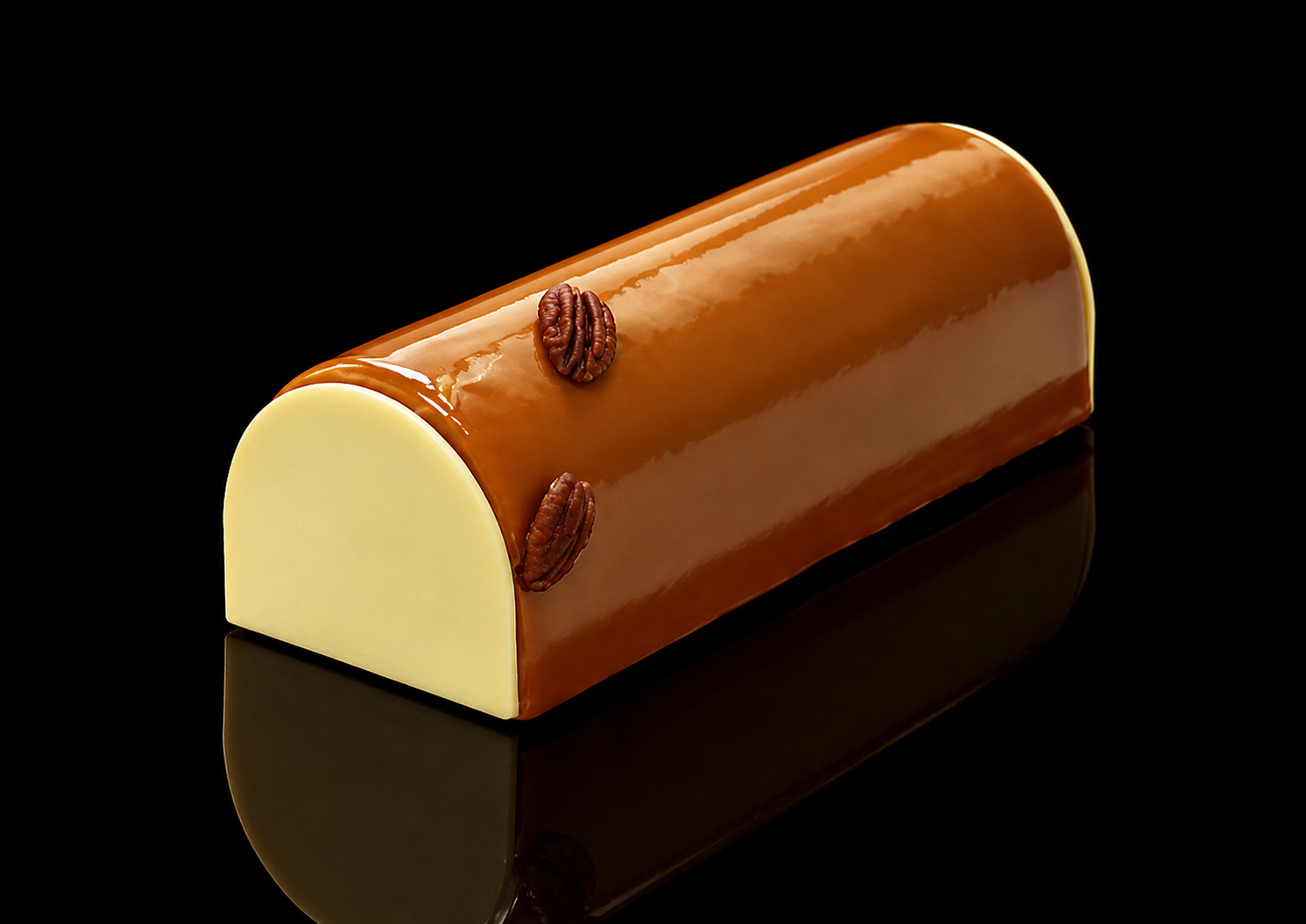 Gâteau en forme de cylindre avec un glaçage brillant au chocolat, décoré de noix de pécan, sur fond noir.