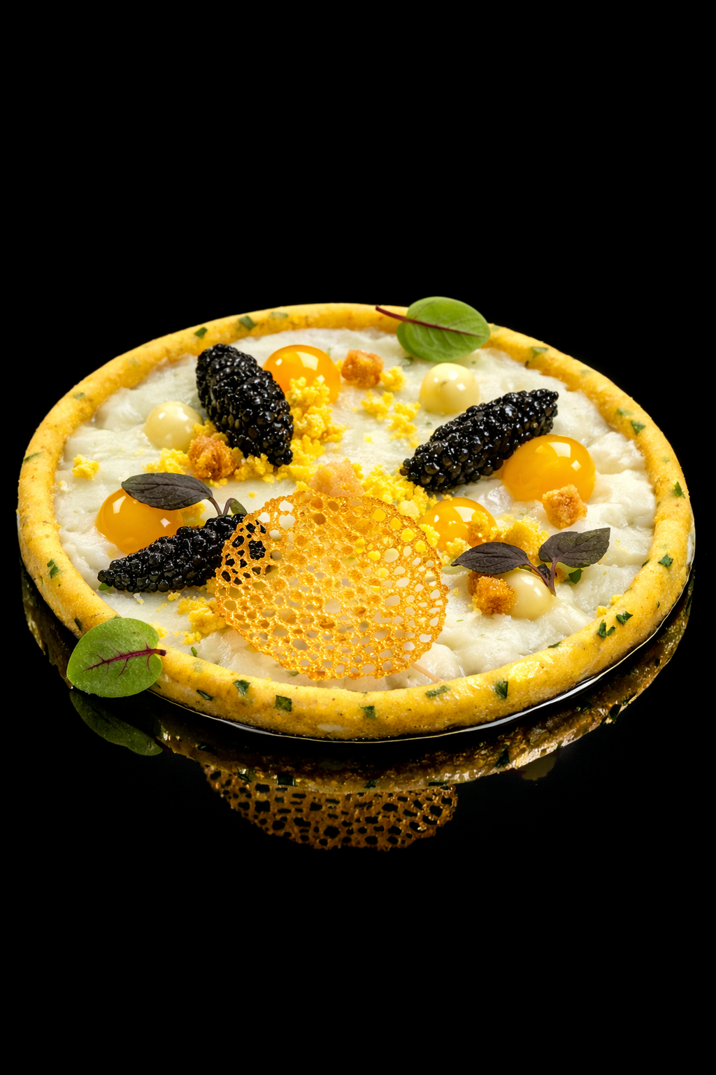 Tarte salée avec œufs de caille, caviar d'algues, feuilles de salade, et garnitures décoratives sur une croûte dorée, contre un fond noir.