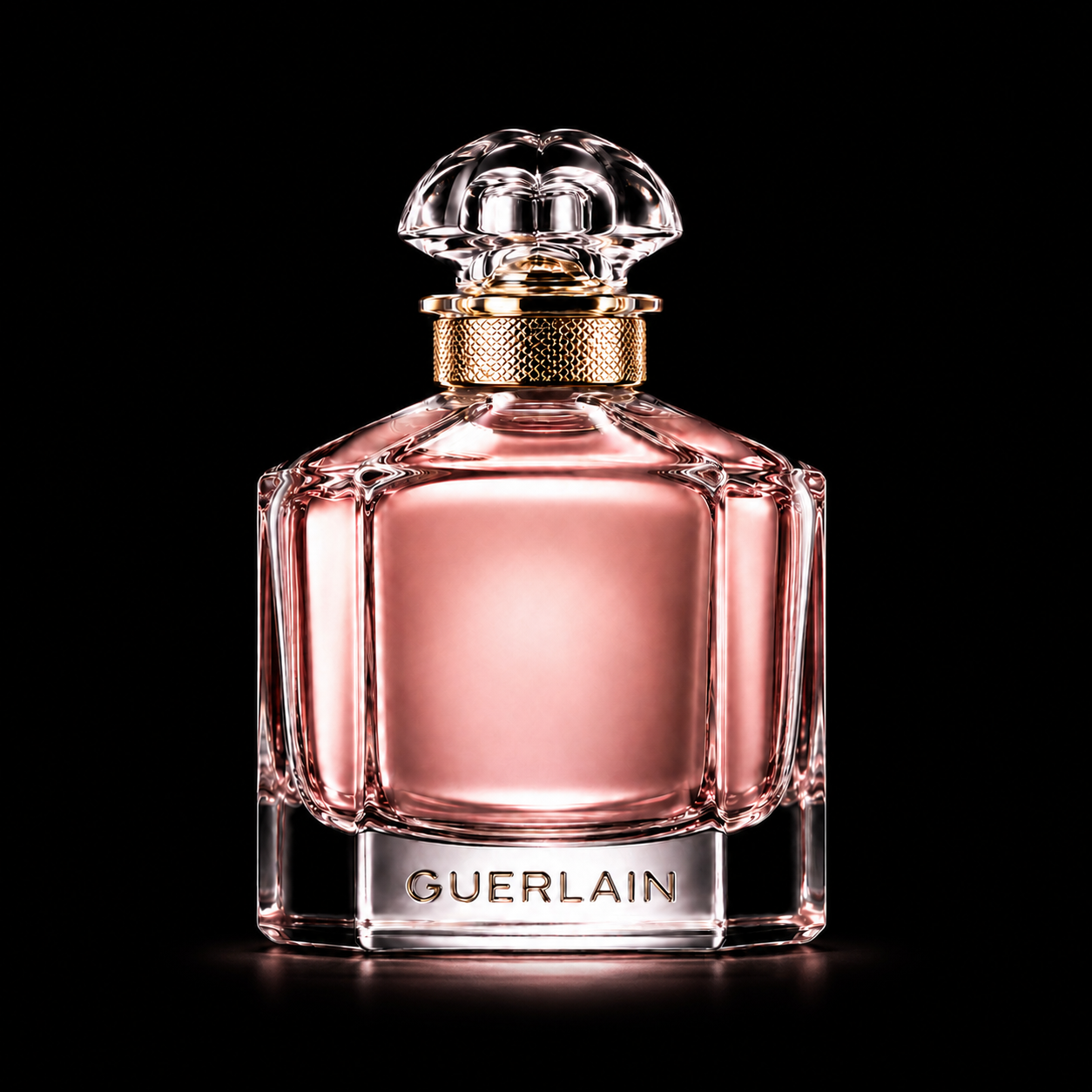 Flacon de parfum rose de Guerlain avec un bouchon en verre orné dans un fond noir.