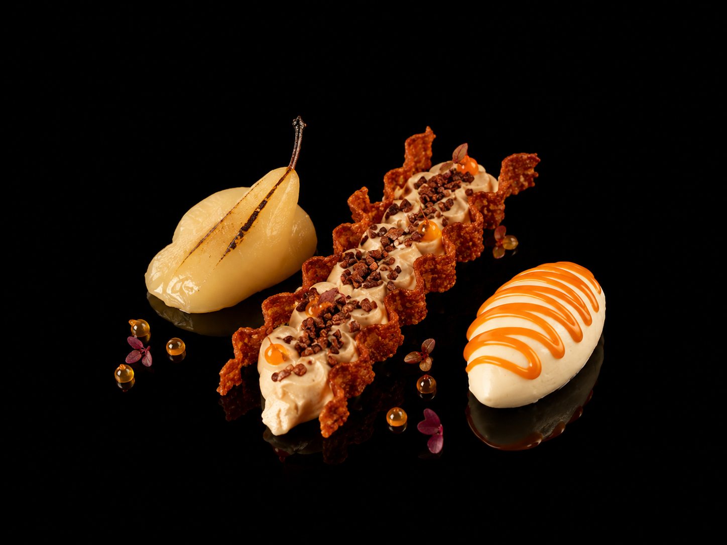 Trois desserts élégants sur un fond noir : une poire pochée pourpre, une tartelette croustillante garnie de crème et de morceaux de chocolat, et un soufflé blanc avec un sirop orange en zigzag. Décorations florales et perles dorées autour.