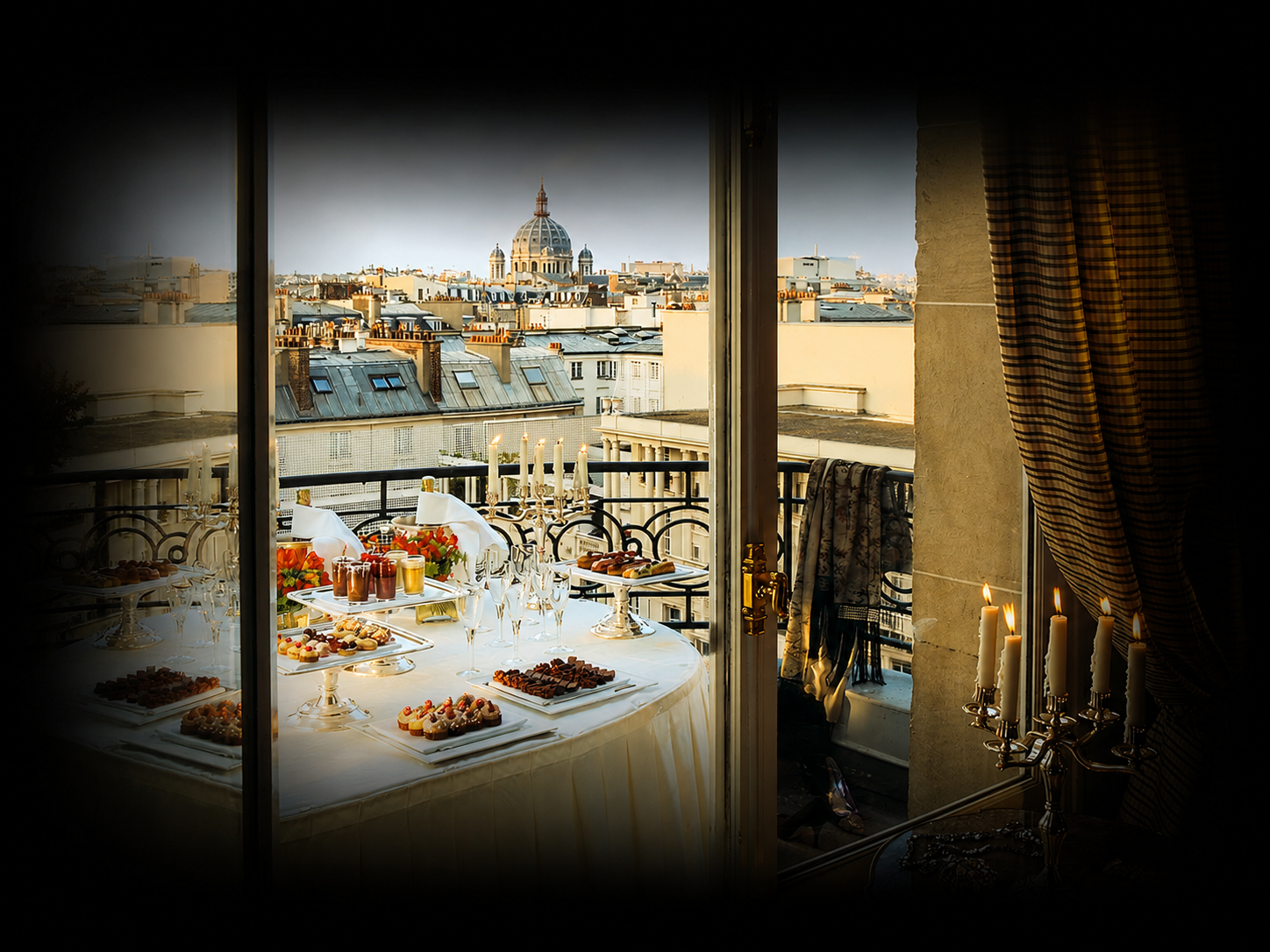 Table de fête avec desserts, boissons et bougies dans un appartement parisien, vue sur le dôme du Sacré-Cœur à travers la fenêtre.