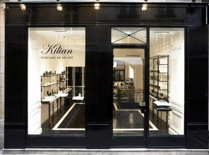 Vitrine d'une boutique de parfums nommé Kilian, avec un intérieur élégant et minimaliste visible à travers la vitrine.