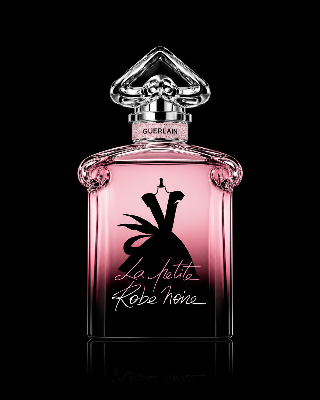 Flacon de parfum Guerlain La Petite Robe Noire, en verre rose avec un bouchon en forme de cœur en cristal et une étiquette noire avec un dessin de robe noire