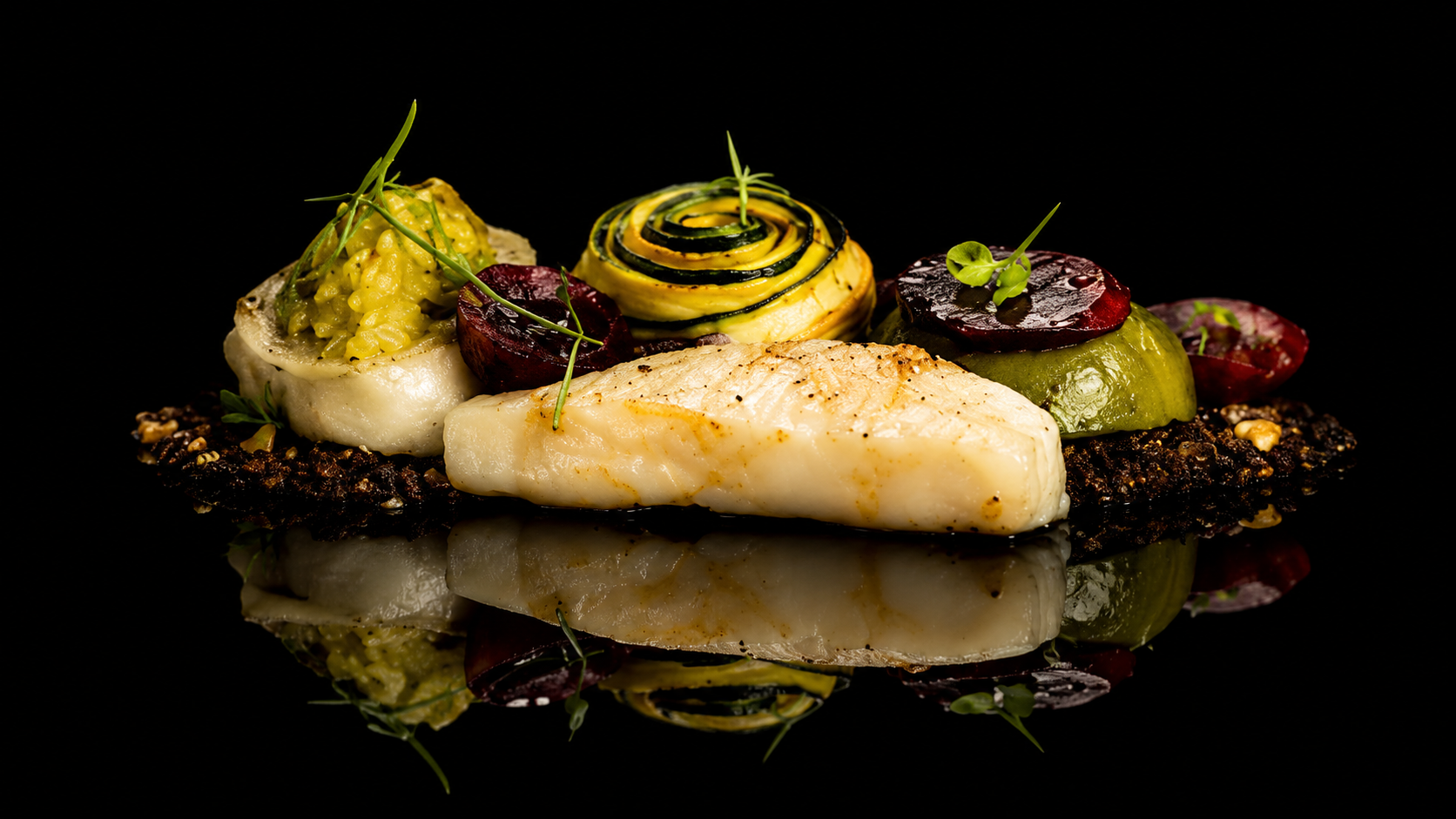 Assiette de poisson blanc avec légumes et garnitures colorées, présentée sur fond noir avec reflet.