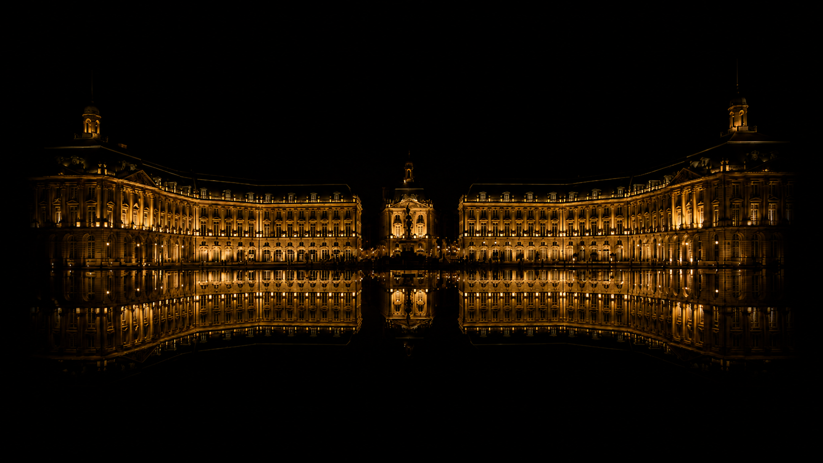 Bâtiment historique illuminé la nuit, avec reflet dans l'eau