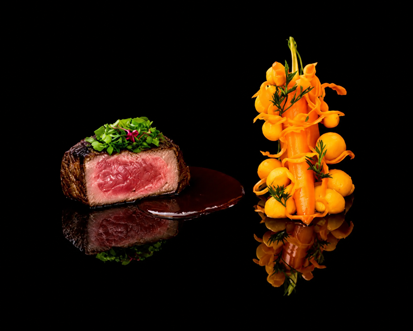 Filet de bœuf Rossini avec une croûte croustillante, servi avec une sauce, et un accompagnement de légumes décoratifs avec des courgettes, carottes, et petits pois, présenté sur une surface noire.