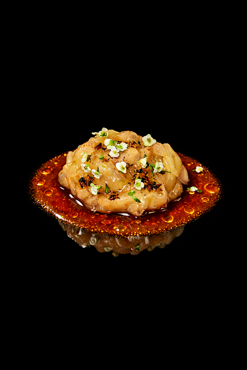 Garniture fine de tartare de poisson avec des fleurs comestibles sur une table noire