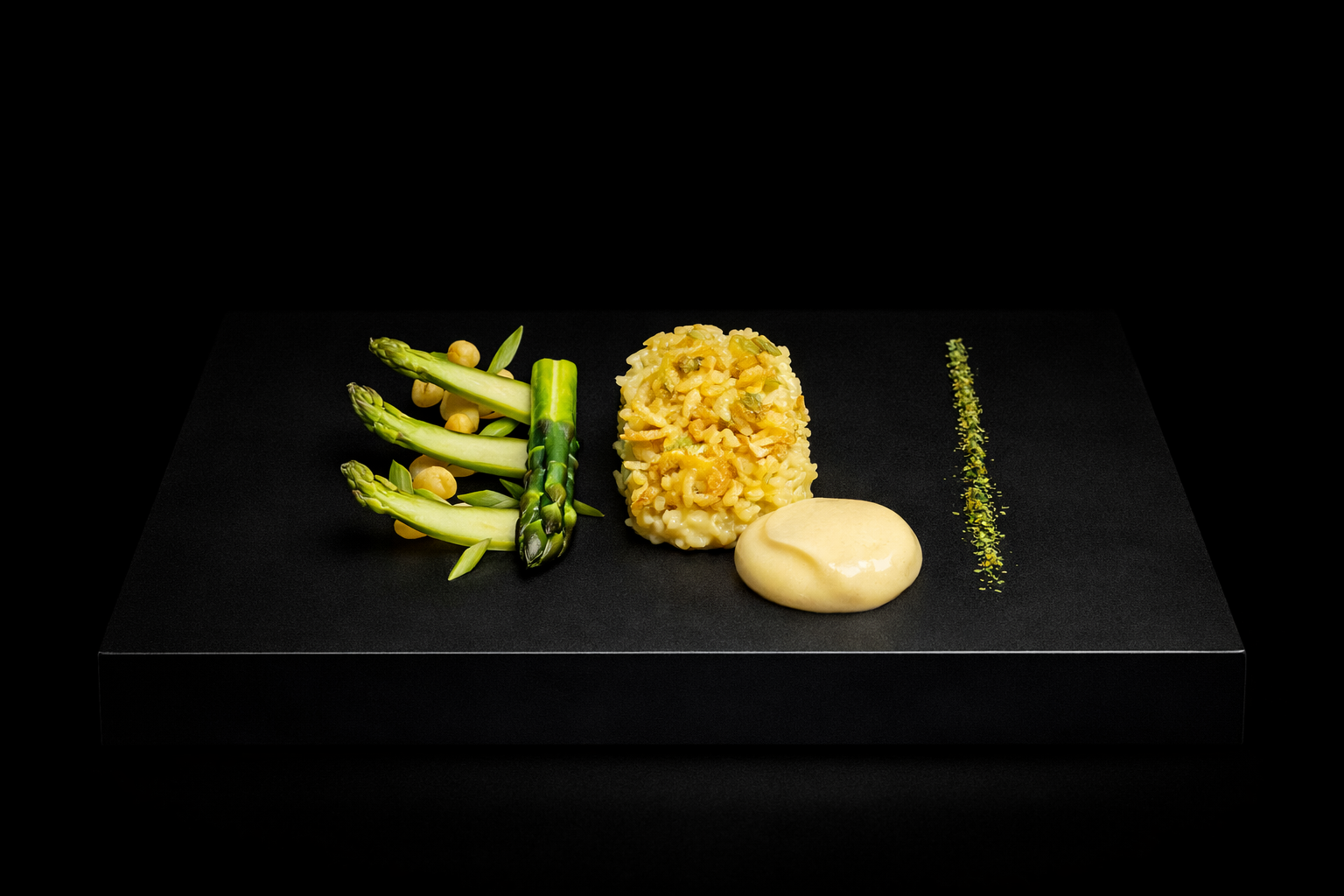 Plat de cuisine gourmet avec des asperges, une portion de risotto, une sauce onctueuse et une fine ligne de poudre verte pour la décoration.