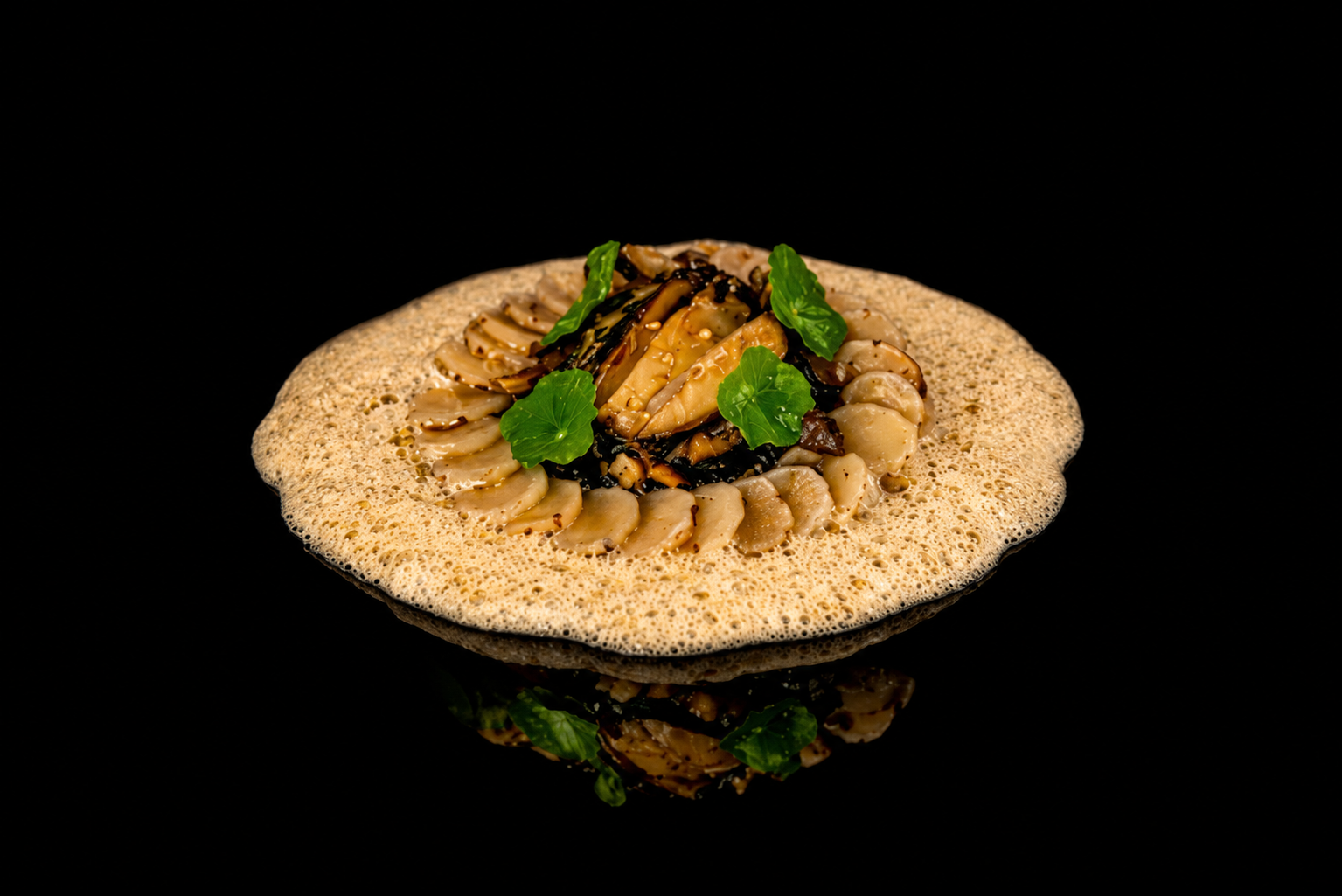 Assiette de plats de fruits de mer avec sauce et garniture verte, sur un fond noir.